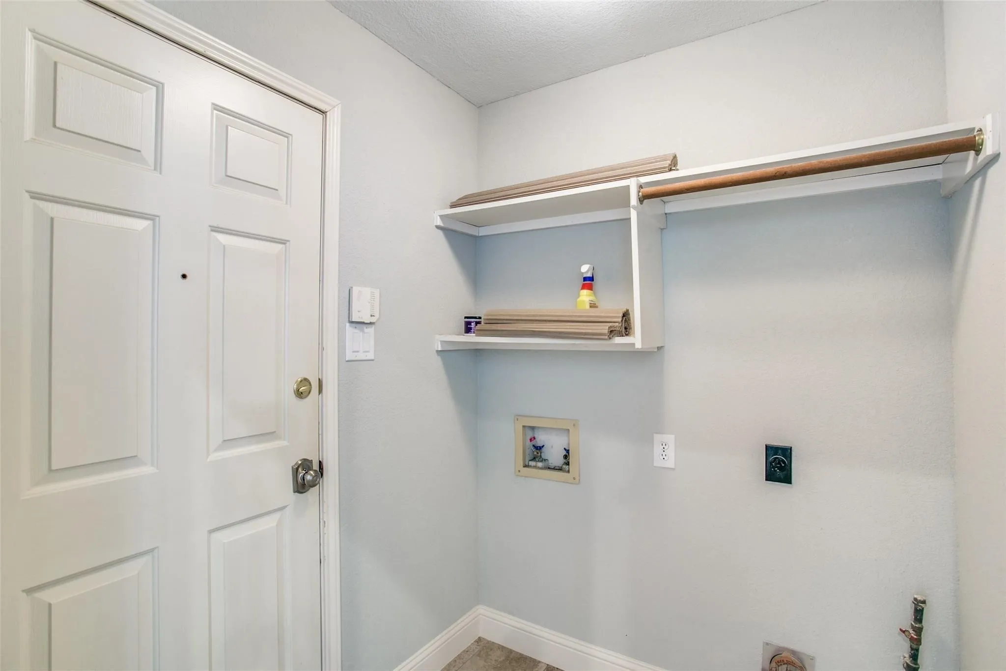 Laundry area featuring a built-in shelving unit, clothes rod, and pre-plumbed connections
