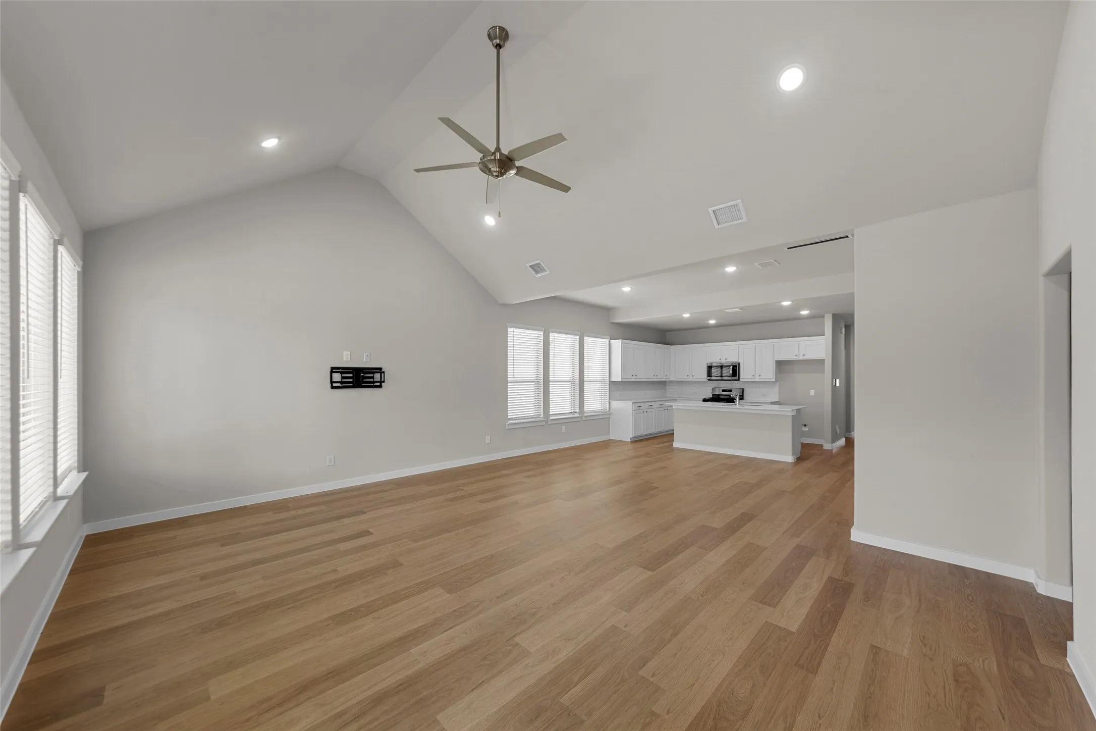 Vaulted ceiling with a ceiling fan and recessed lighting