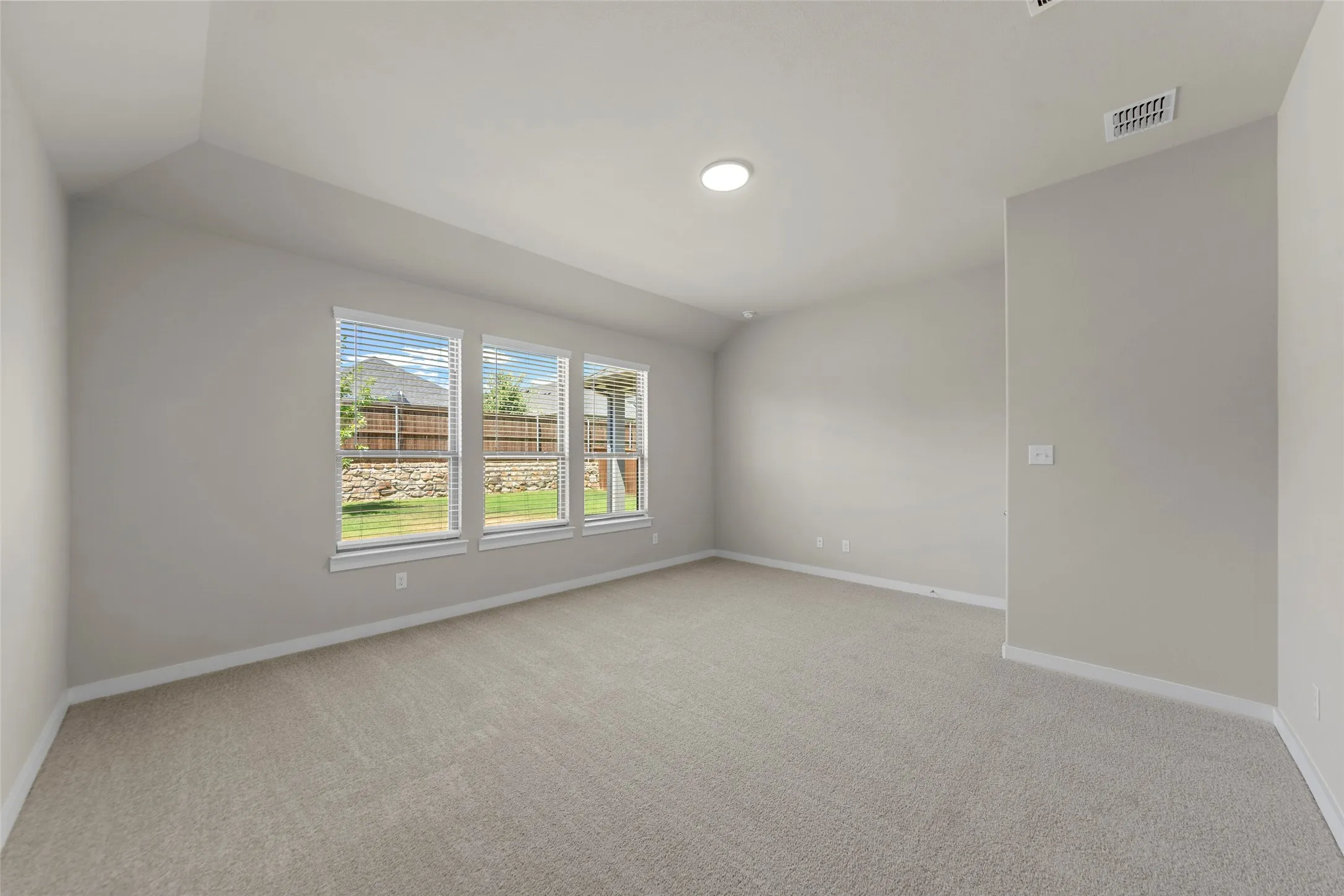 Wall-to-wall carpeting with recessed lighting and multiple windows