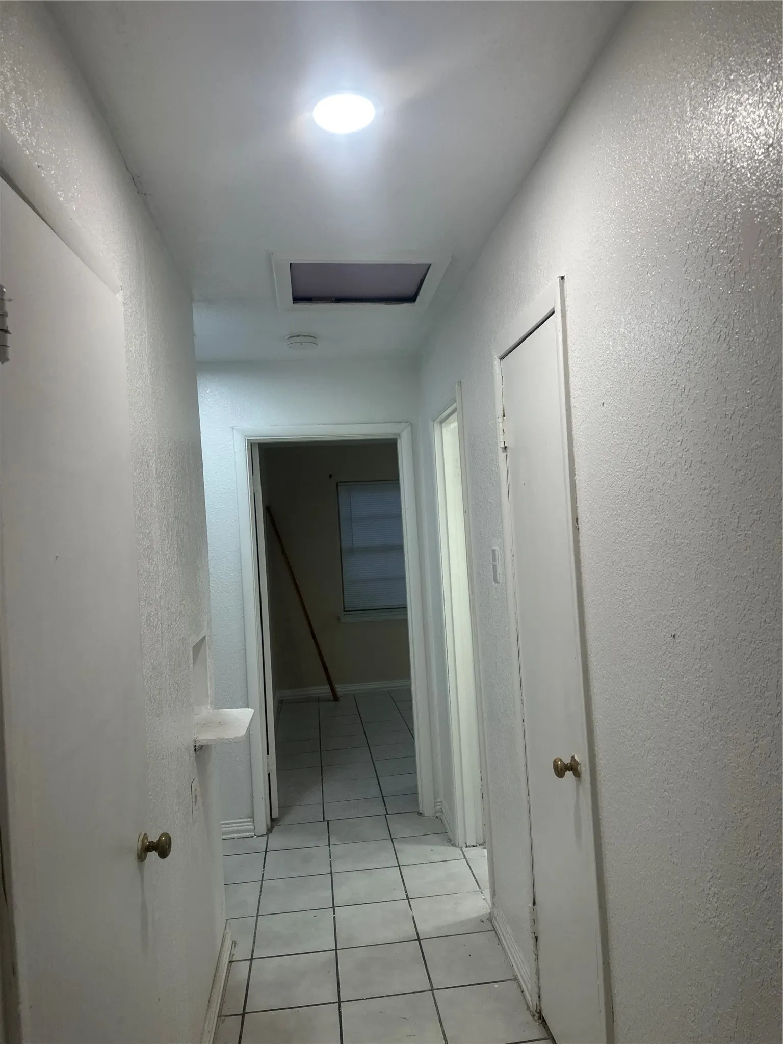 White tile flooring extending through the hallway