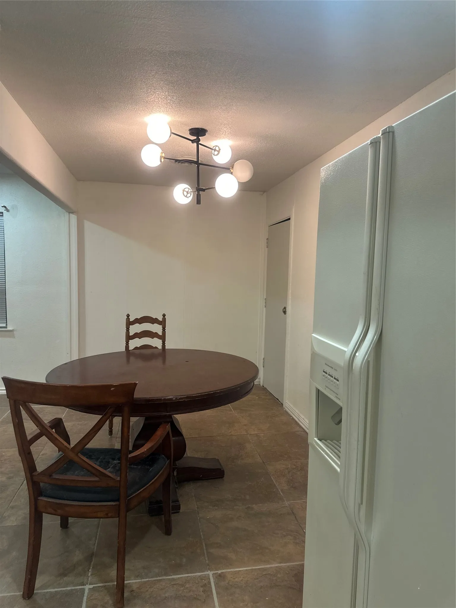 Terrazzo-style flooring, white walls, and a contemporary ceiling light fixture
