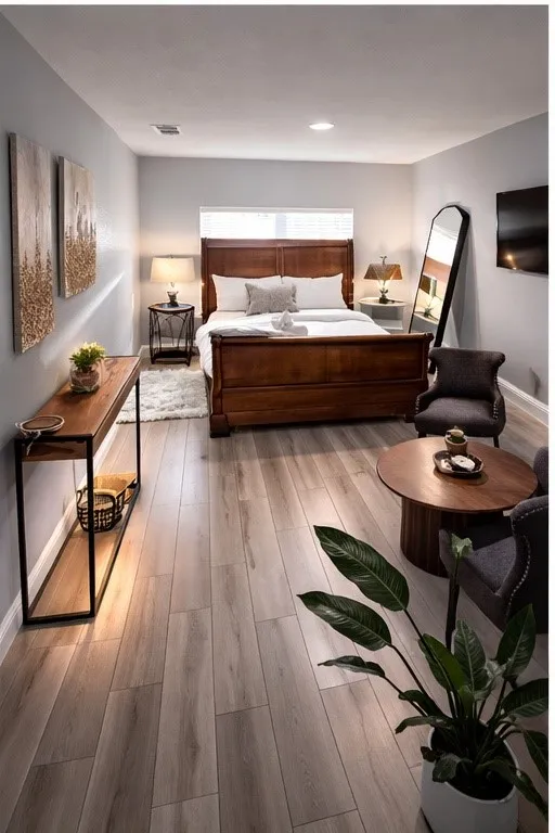 Recessed lighting illuminates wood-finish plank flooring throughout