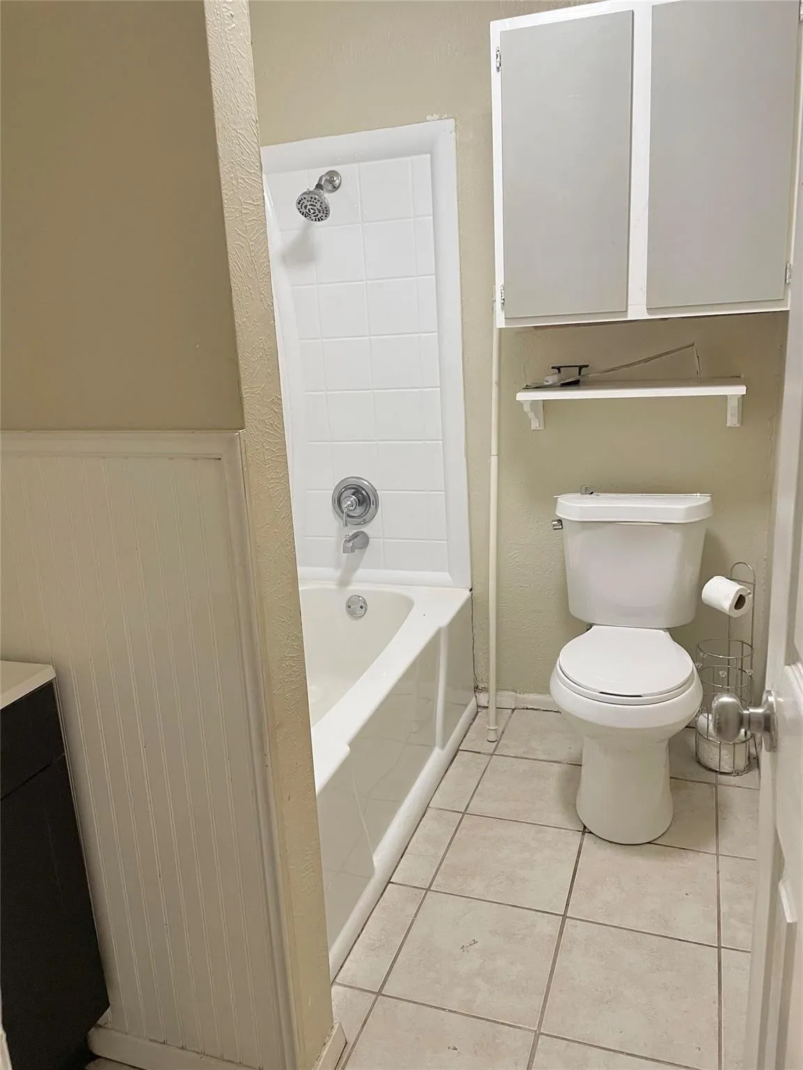 Primary Bathroom featuring tile patterned flooring, toilet, and bathtub / shower combination