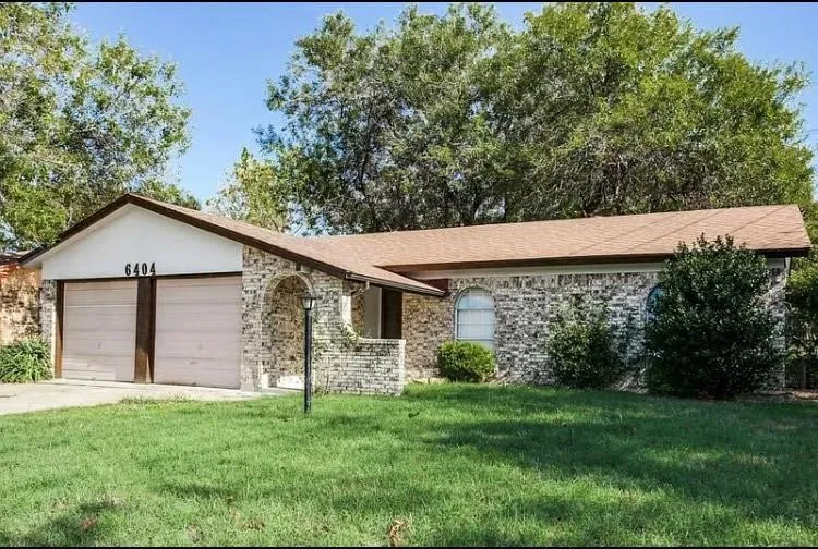 Single story home with a garage and a front yard