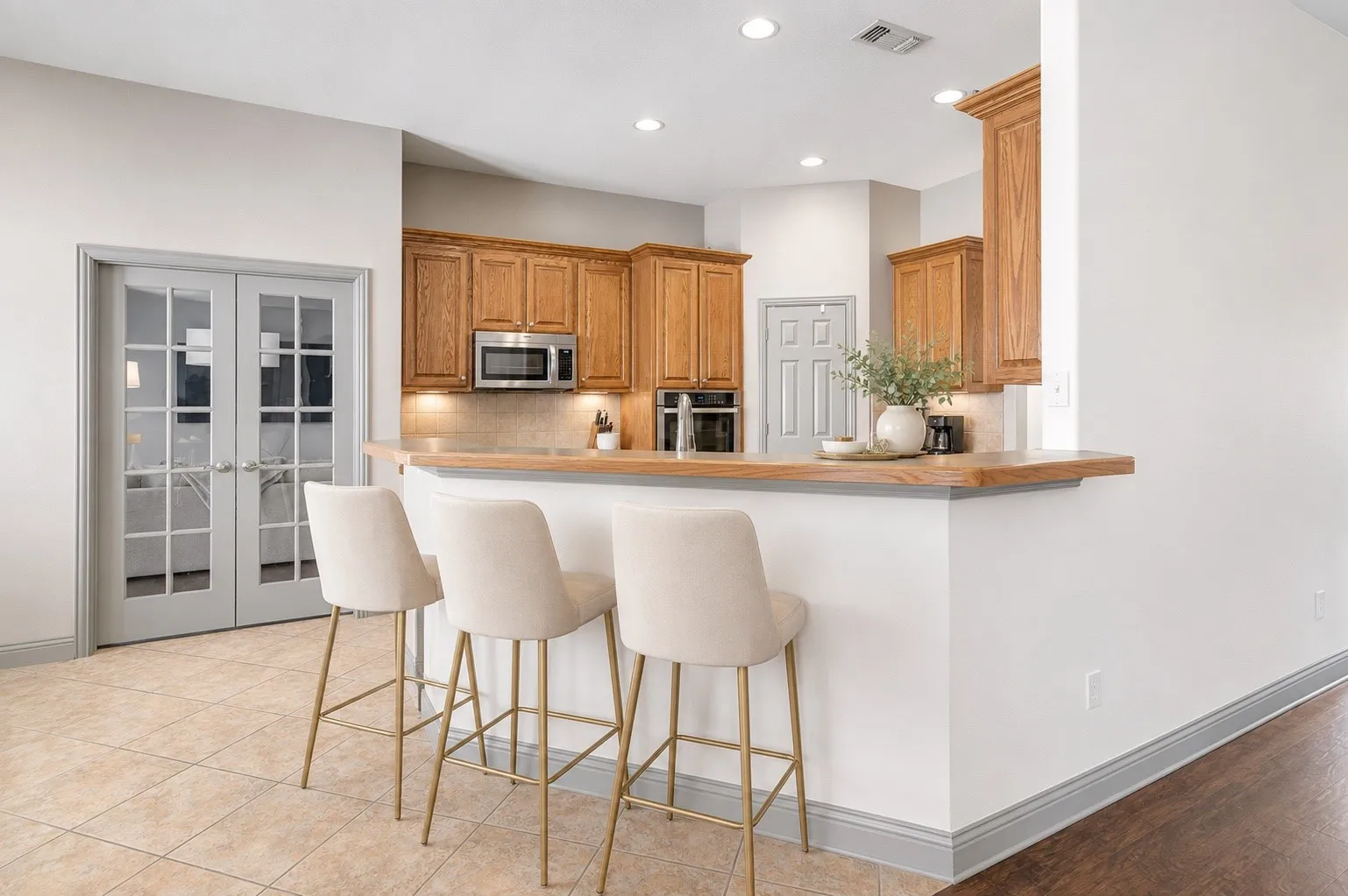Kitchen featuring wood-finish cabinetry, stainless steel microwave, and recessed lighting
