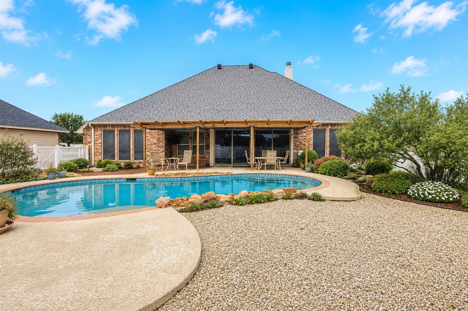 Brick exterior with a shingle roof and a covered patio area