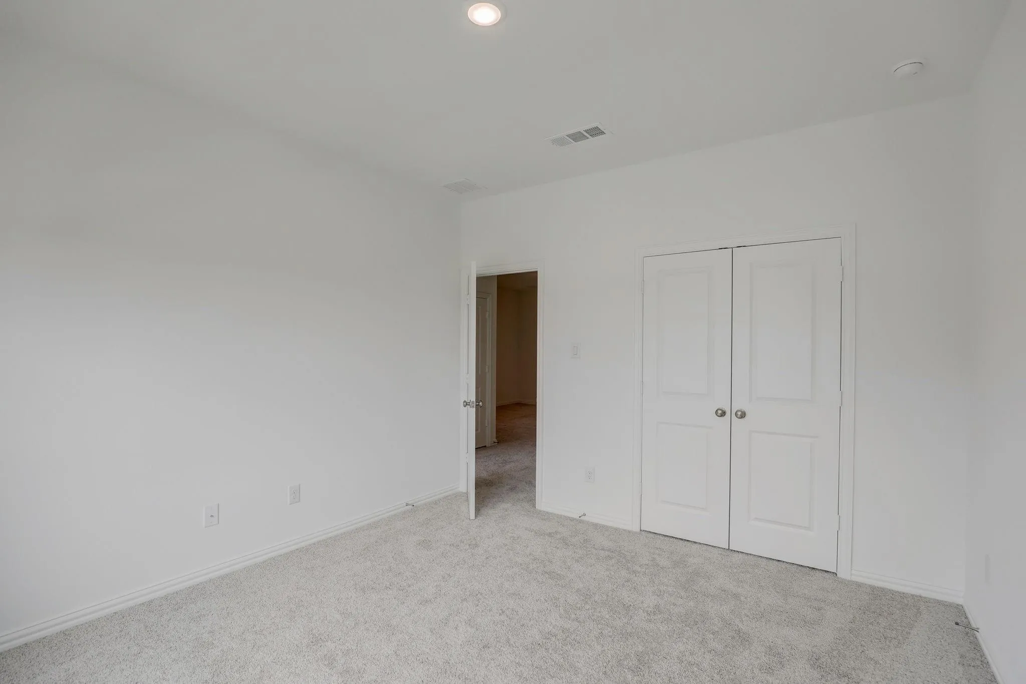 Plush carpet flooring, double panel closet doors, and recessed ceiling lighting