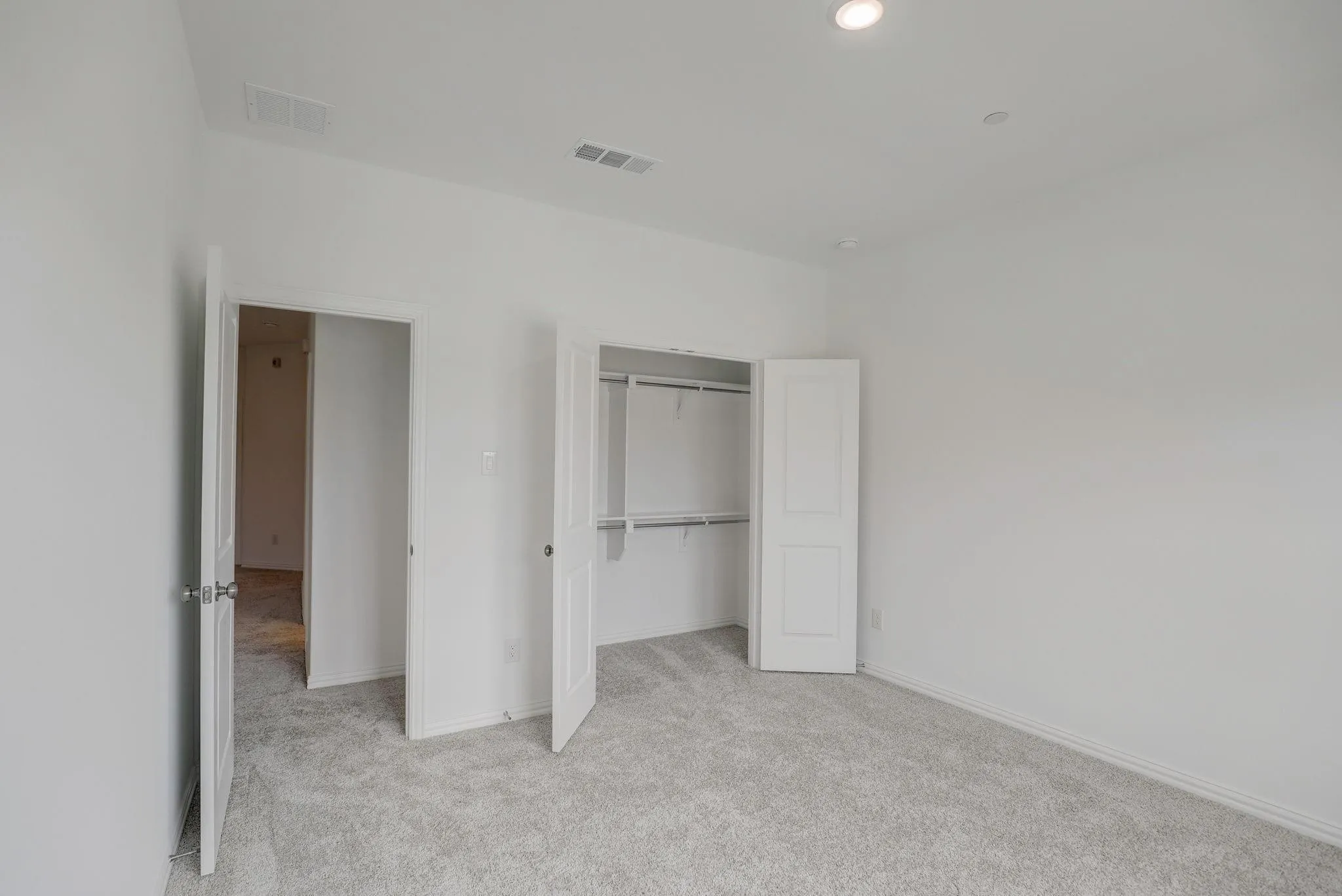 Light gray carpet flooring and recessed lighting