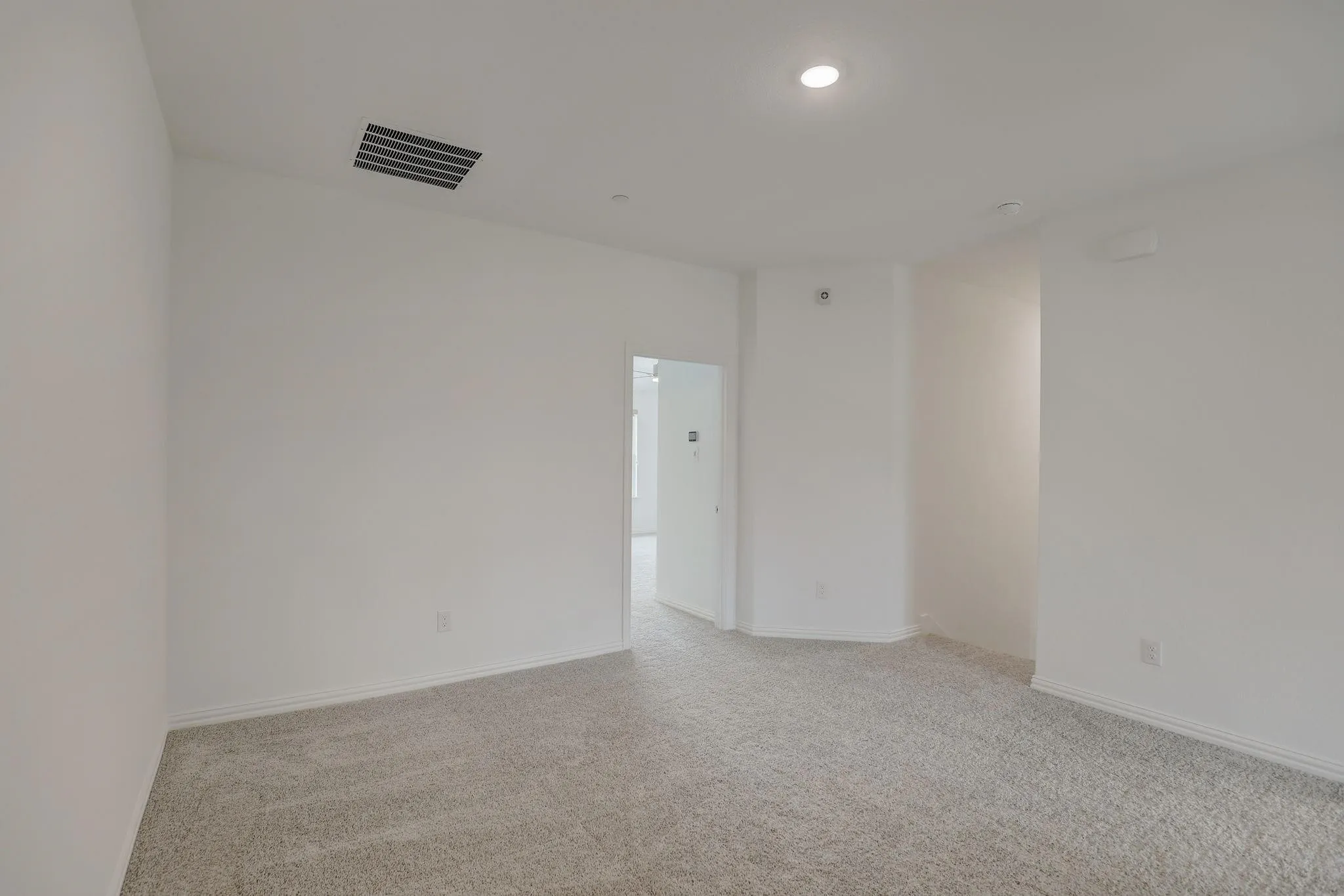 Neutral wall colors, recessed ceiling lighting, textured carpeting, and white trim
