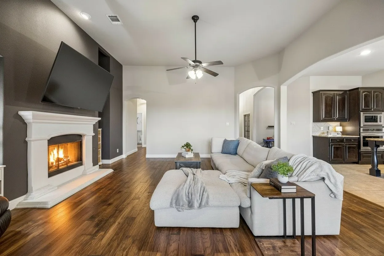 Spacious family room features updated lighting, warm wood flooring, fireplace and an open connection to the kitchen and breakfast area.