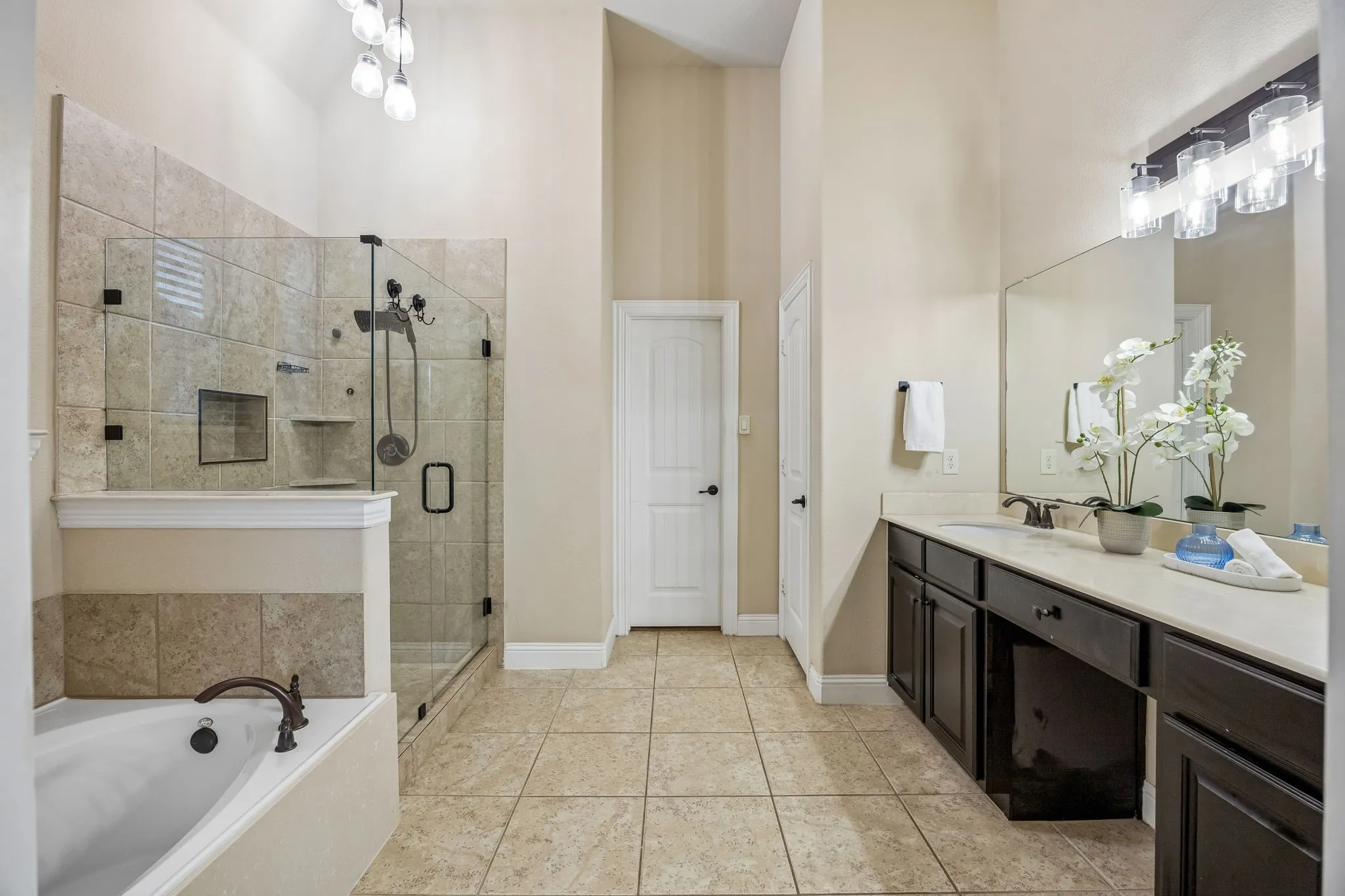Primary bath features dual vanities, soaking tub and an upgraded frameless glass shower enclosure.