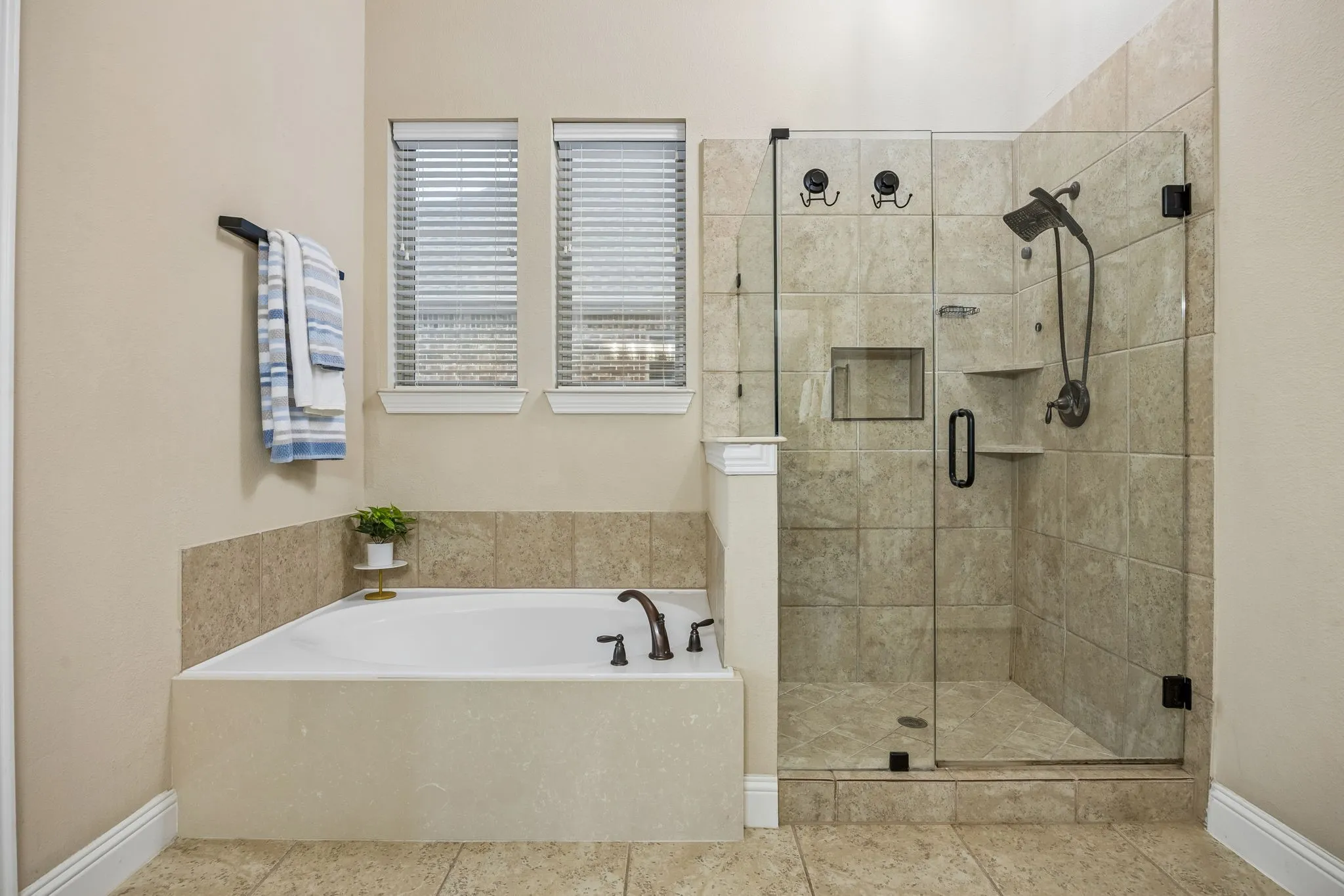 Primary bath combines a soaking tub, separate frameless glass shower and dual-sink vanity.