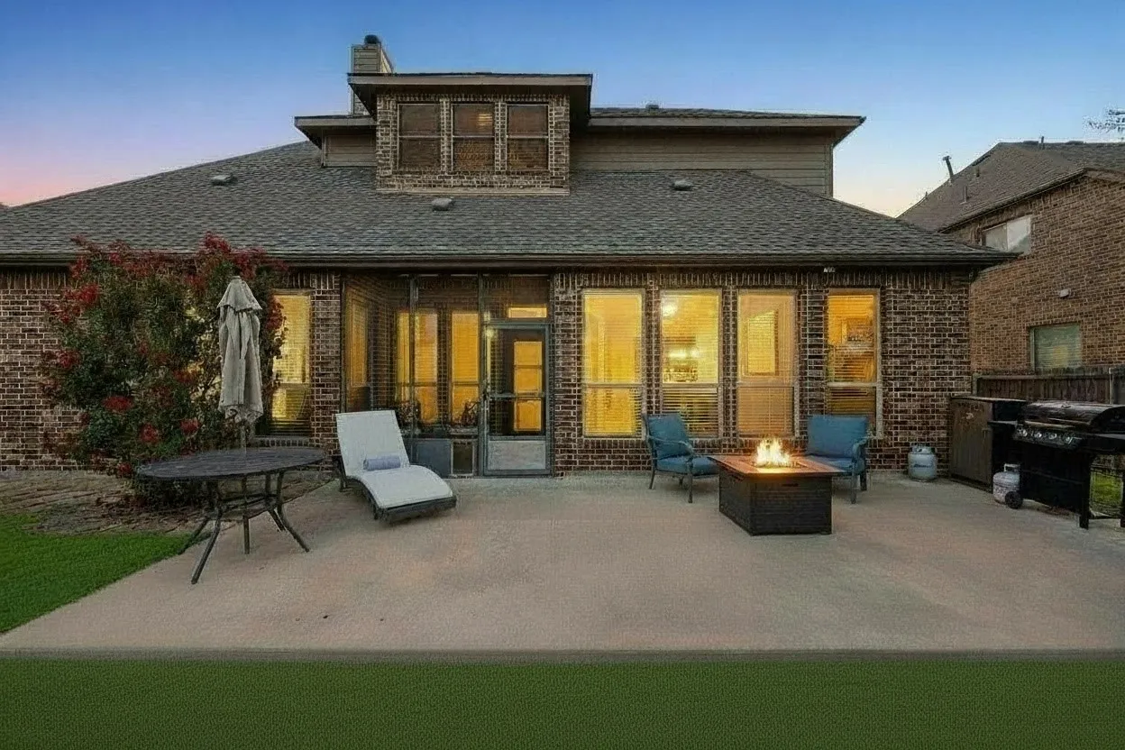 Evening view of the backyard and covered outdoor living area creates an inviting setting for relaxing or entertaining.