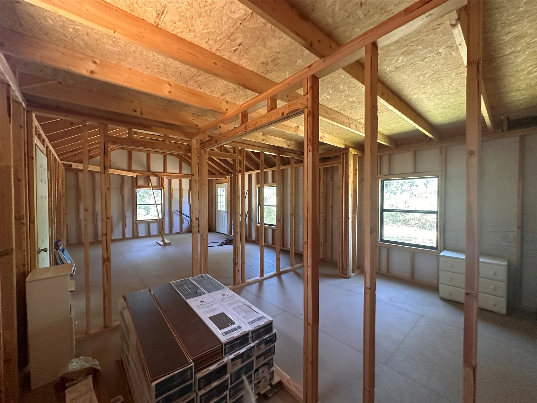 Exposed wood framing with multiple window openings, and a visible door frame