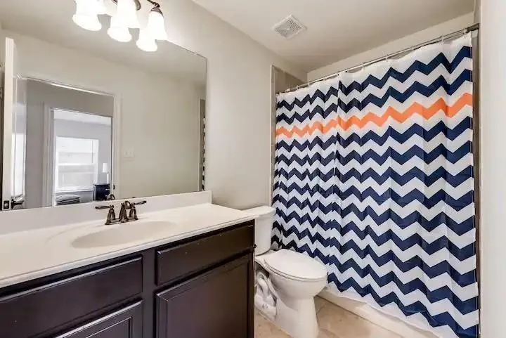 Vanity with a single basin sink, bronze-finish faucet, and white countertop
