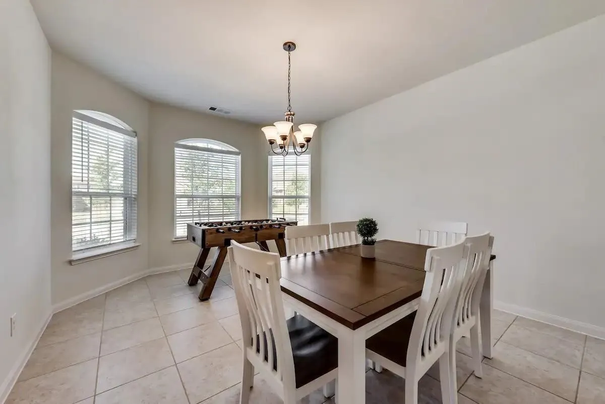 Bay window with arched transoms, tile flooring, and a multi-arm chandelier