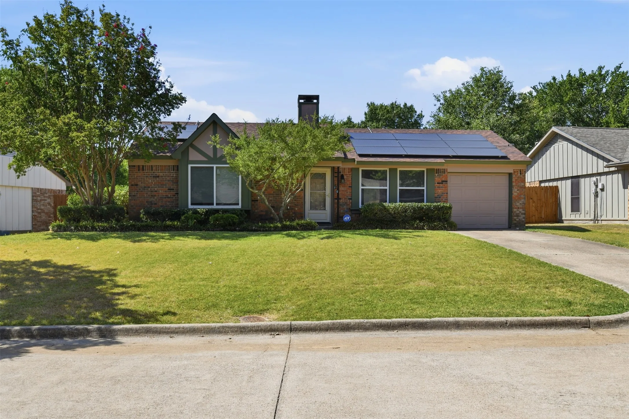 Brick exterior featuring a gabled roof and solar panel installation