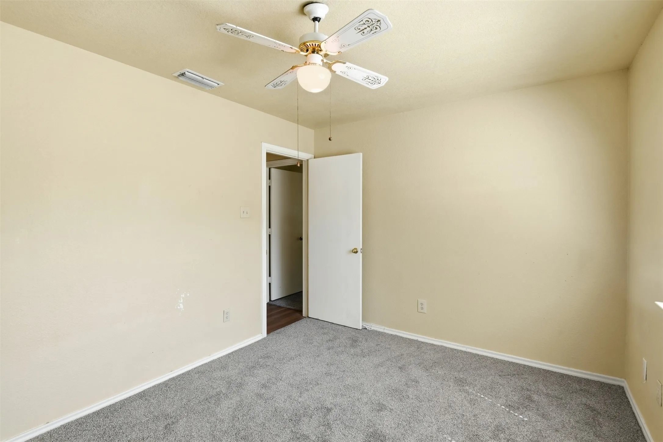 Neutral wall tones with gray carpeting, ceiling fan with integrated lighting, and white trim molding