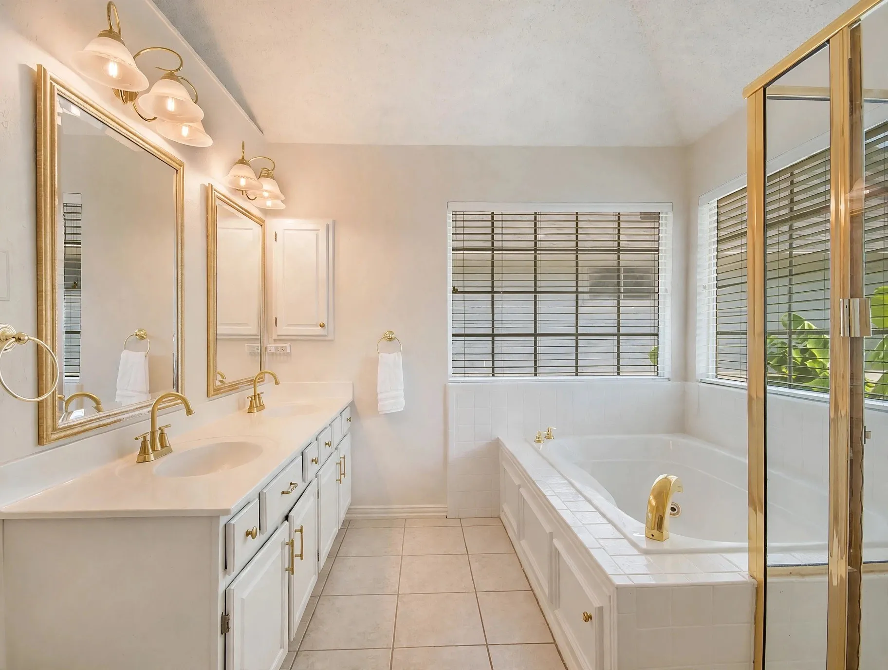 Dual vanity with gold-tone fixtures and framed mirrors