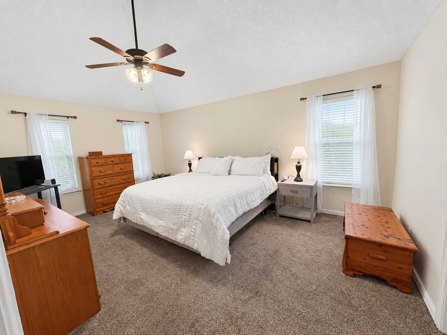 Neutral-toned walls complement the textured carpet flooring
