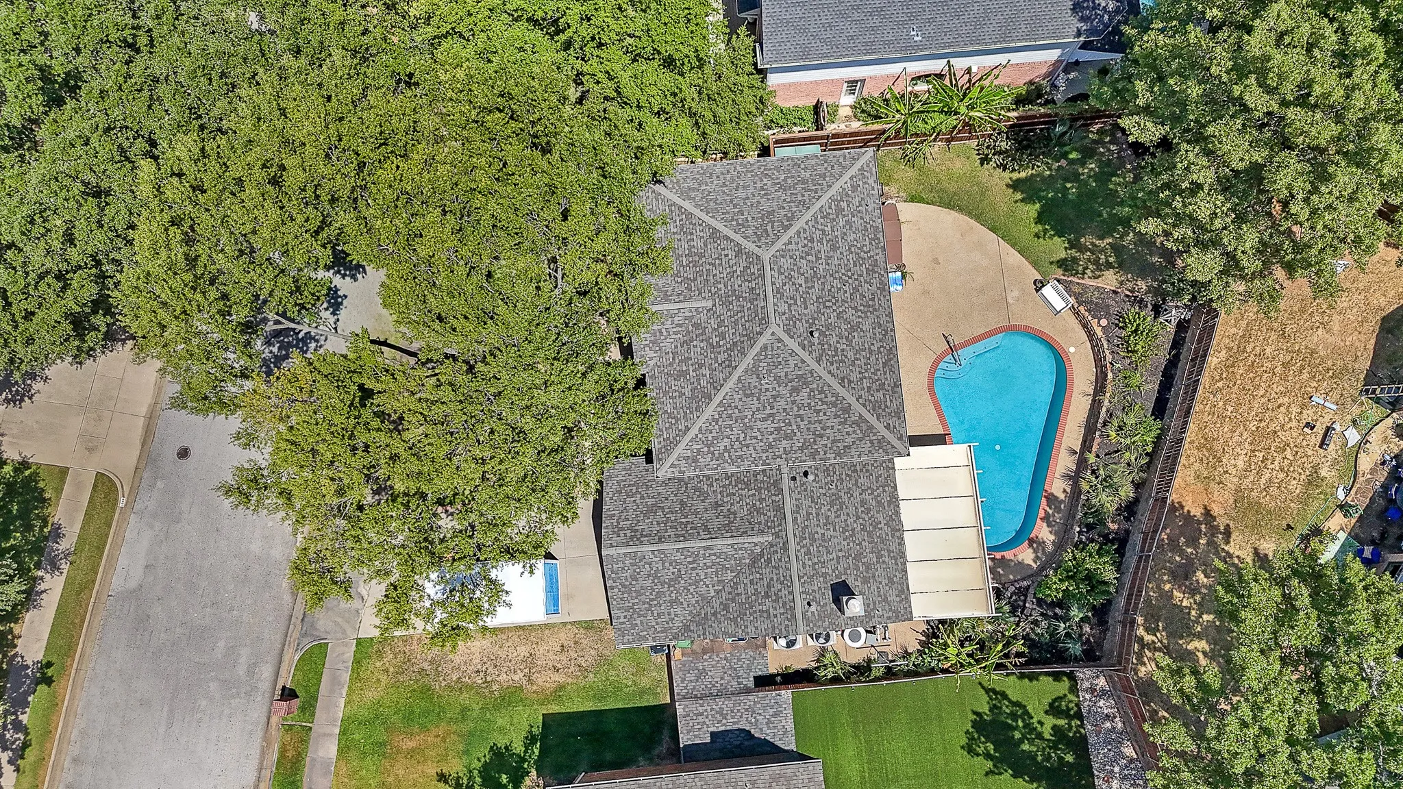 Brick facade residence with a two-car garage, mature landscaping, and an expansive lawn