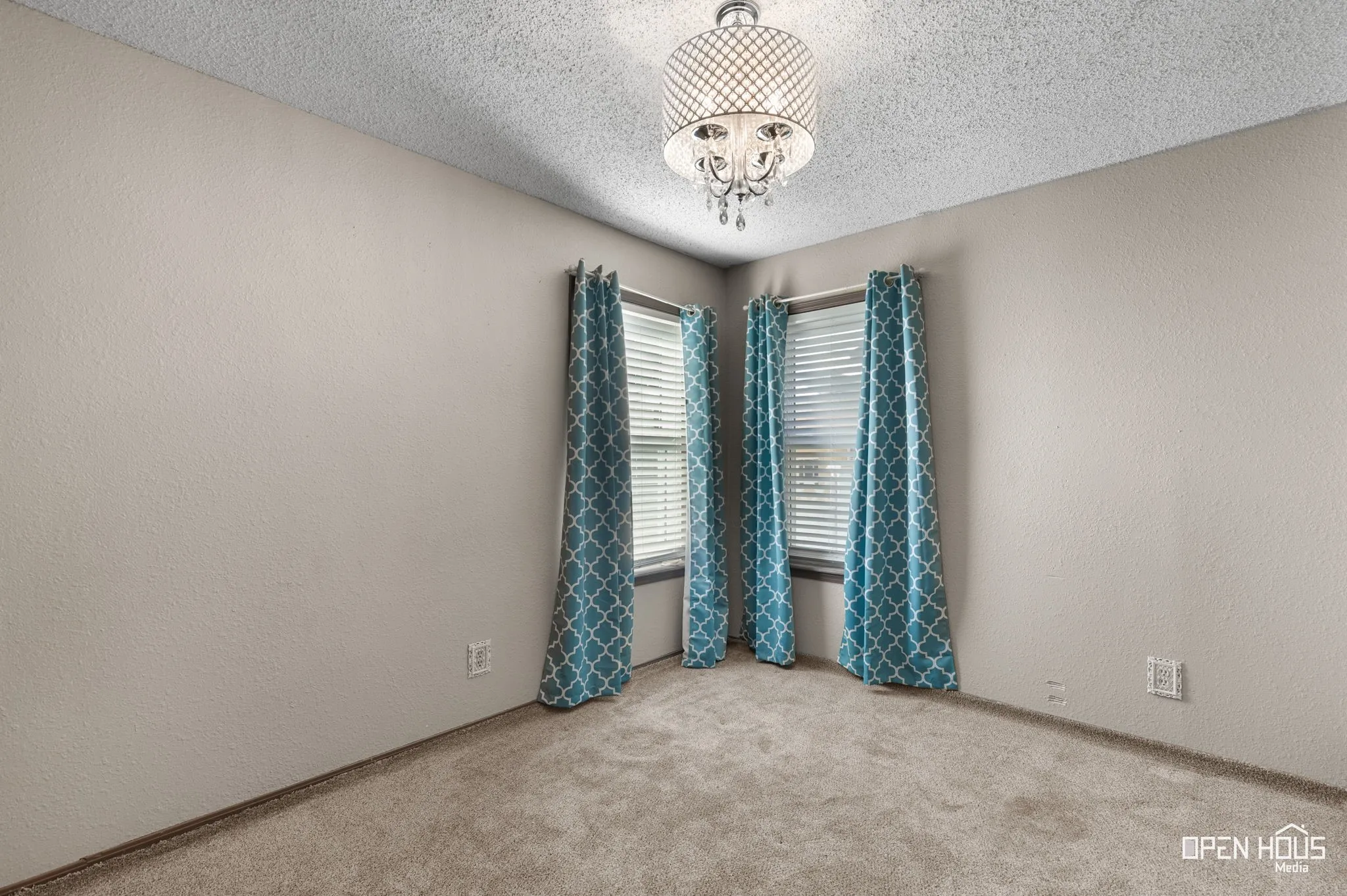 Plush carpet flooring, neutral painted walls, and a decorative semi-flush mount light fixture