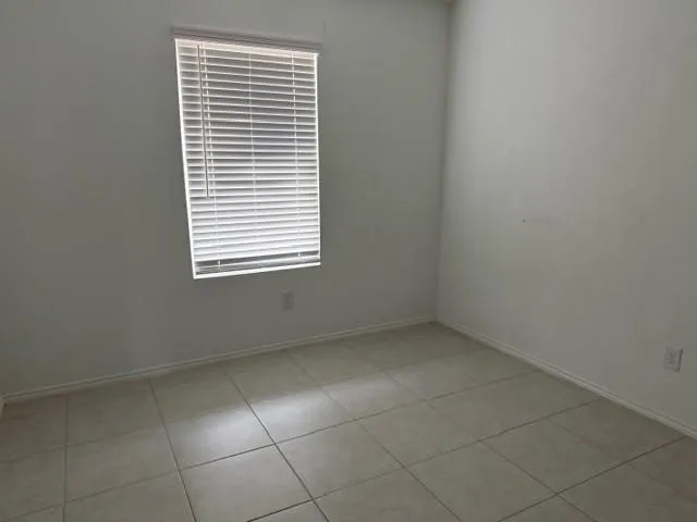 Recessed window with blinds, light tile flooring