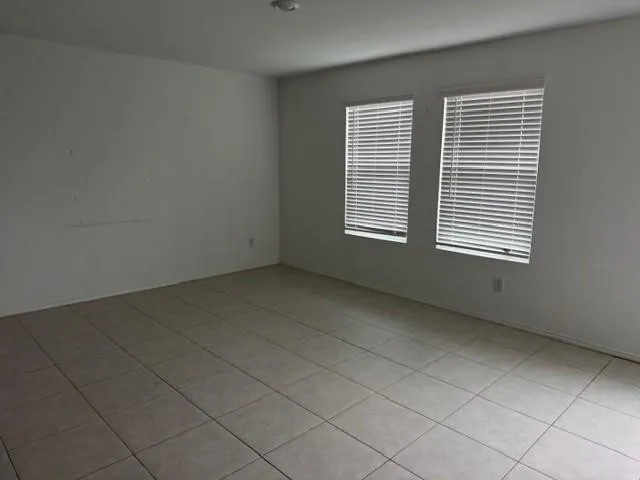Light-toned tile flooring, dual windows with blinds, and recessed lighting