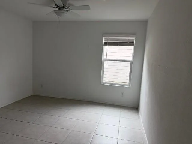 Tile flooring, single window with blinds, and a ceiling fan with integrated lighting