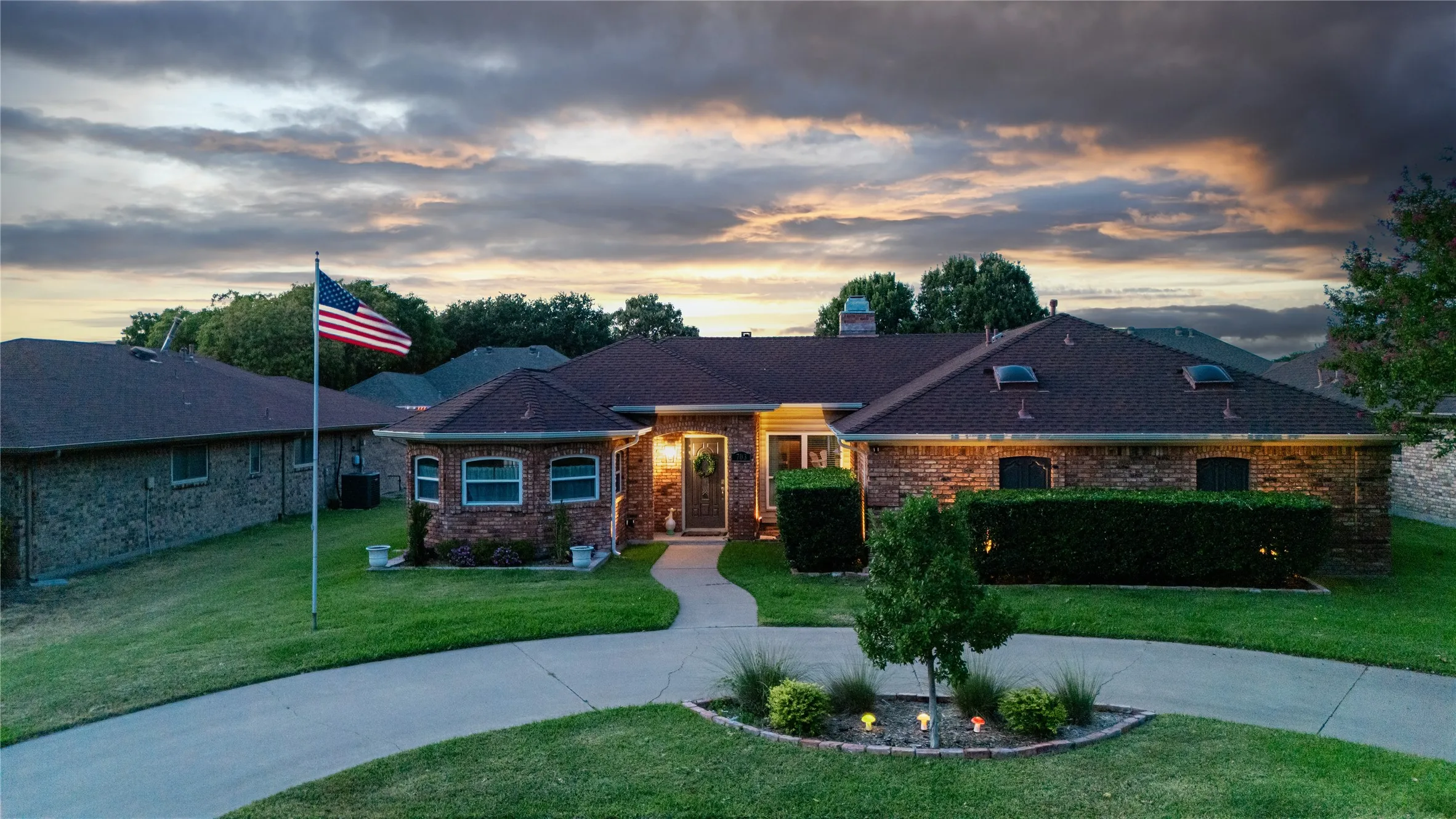 Brick exterior with a dark shingle roof and multiple skylights