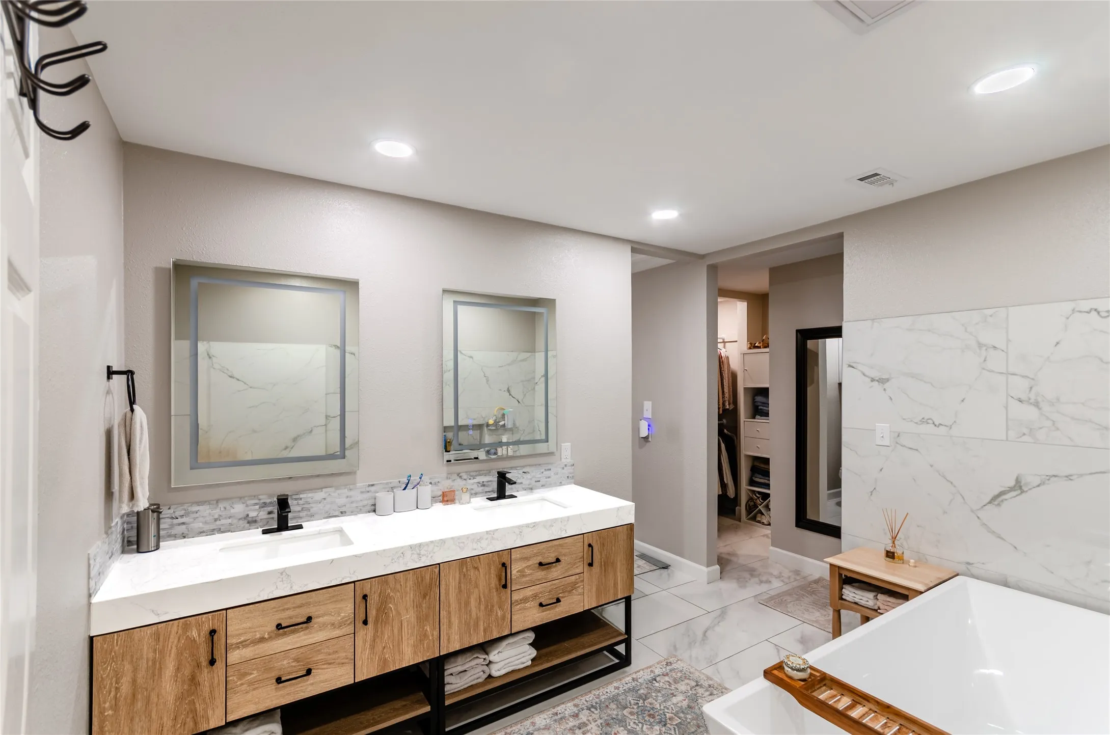 Dual vanity with wood-finish cabinetry, integrated sinks, and matte black fixtures