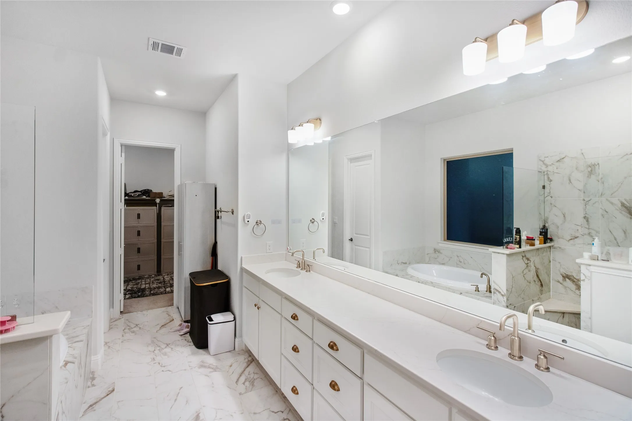 Dual vanity with undermount sinks, a soaking tub, and a separate shower with a glass enclosure