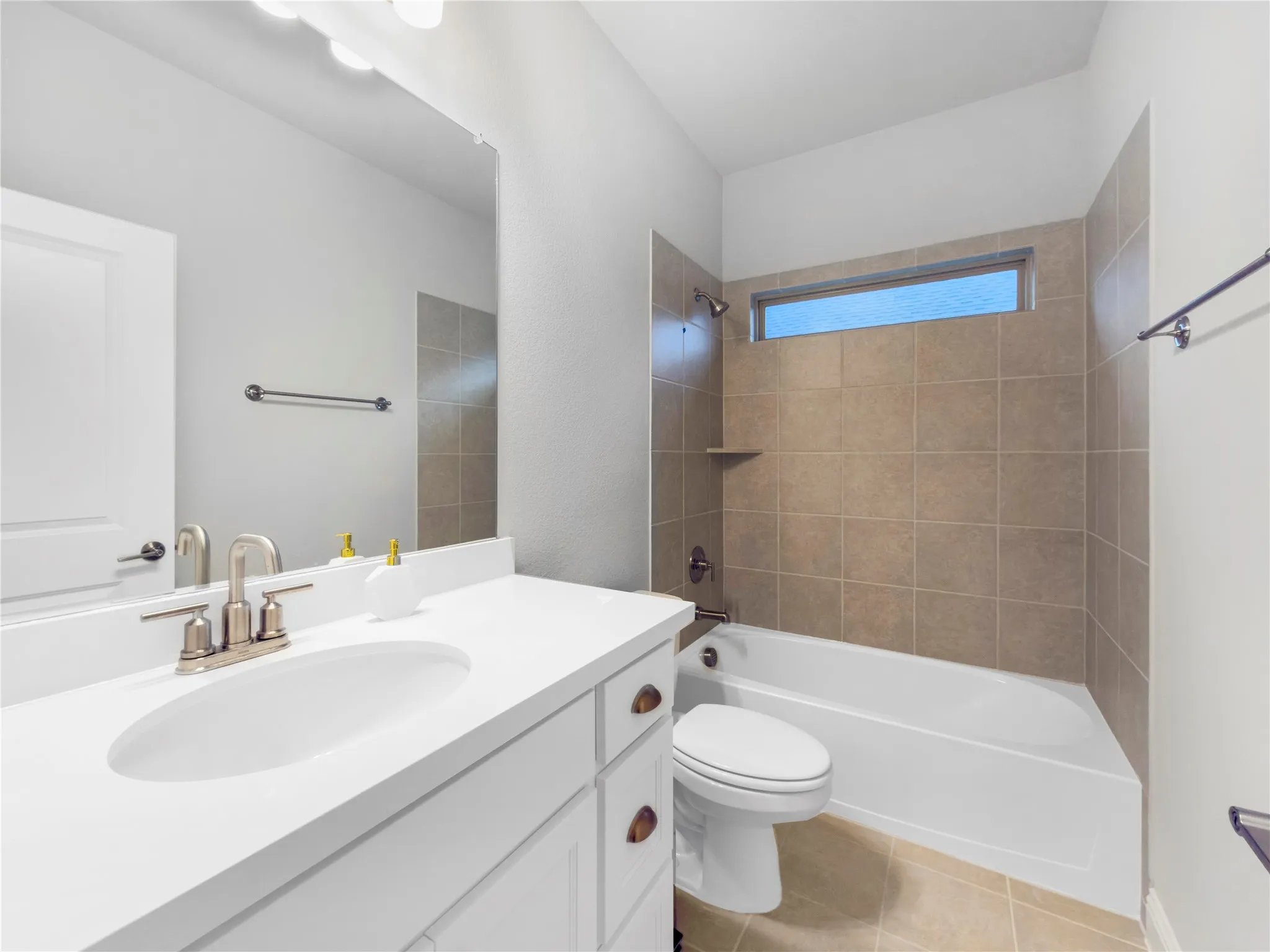 White vanity with integrated sink, brushed nickel faucet, large mirror, and overhead vanity lighting