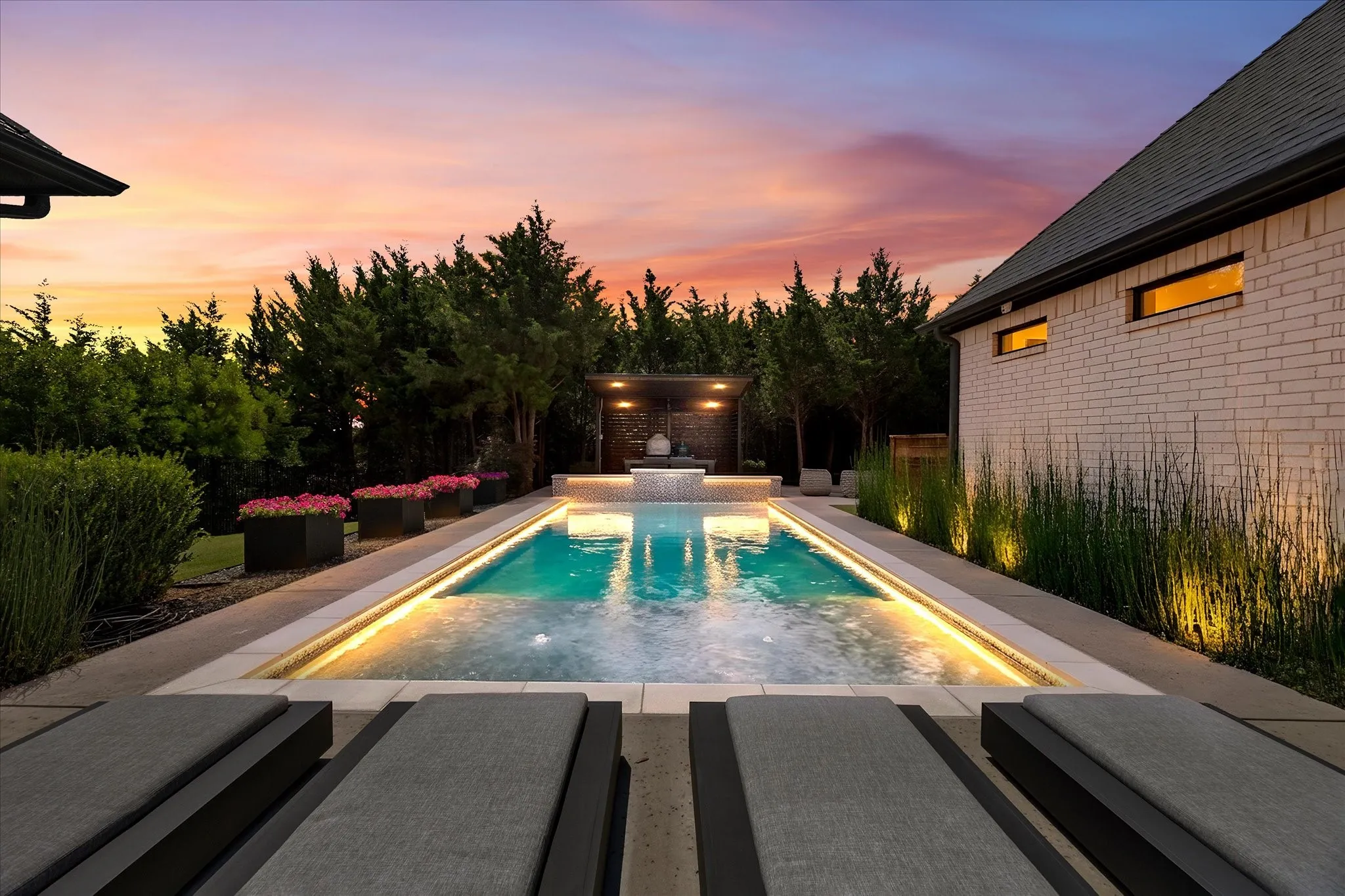 Rectangular pool with integrated lighting, a raised spa, and a covered lounge area