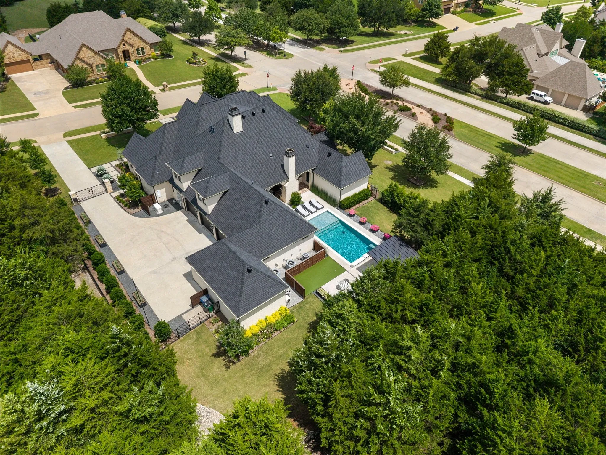 Expansive property featuring a multi-level residence with a large driveway, private swimming pool, and an established perimeter of mature trees