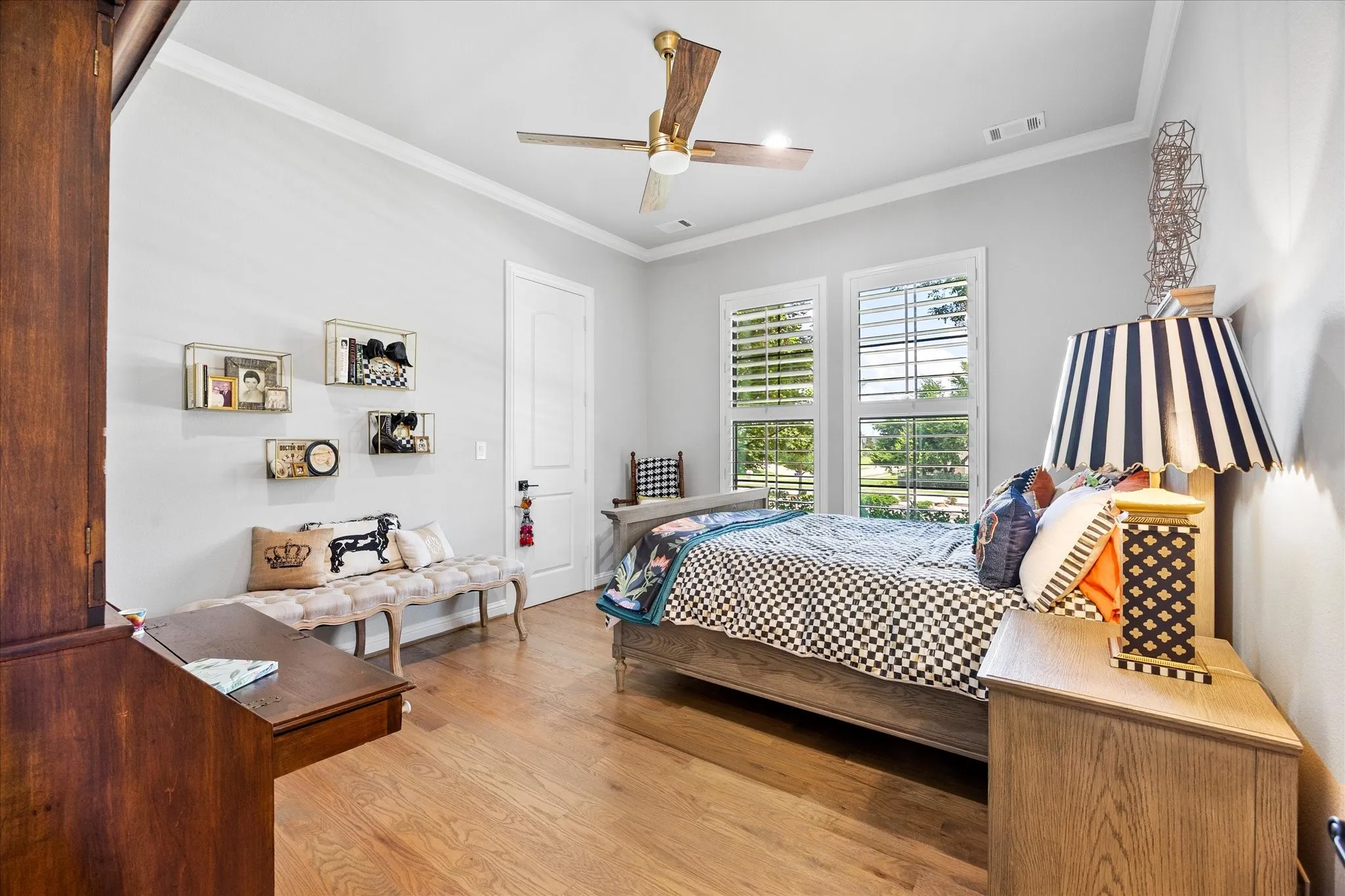 Wood-finish flooring, crown molding, and a ceiling fan with integrated lighting