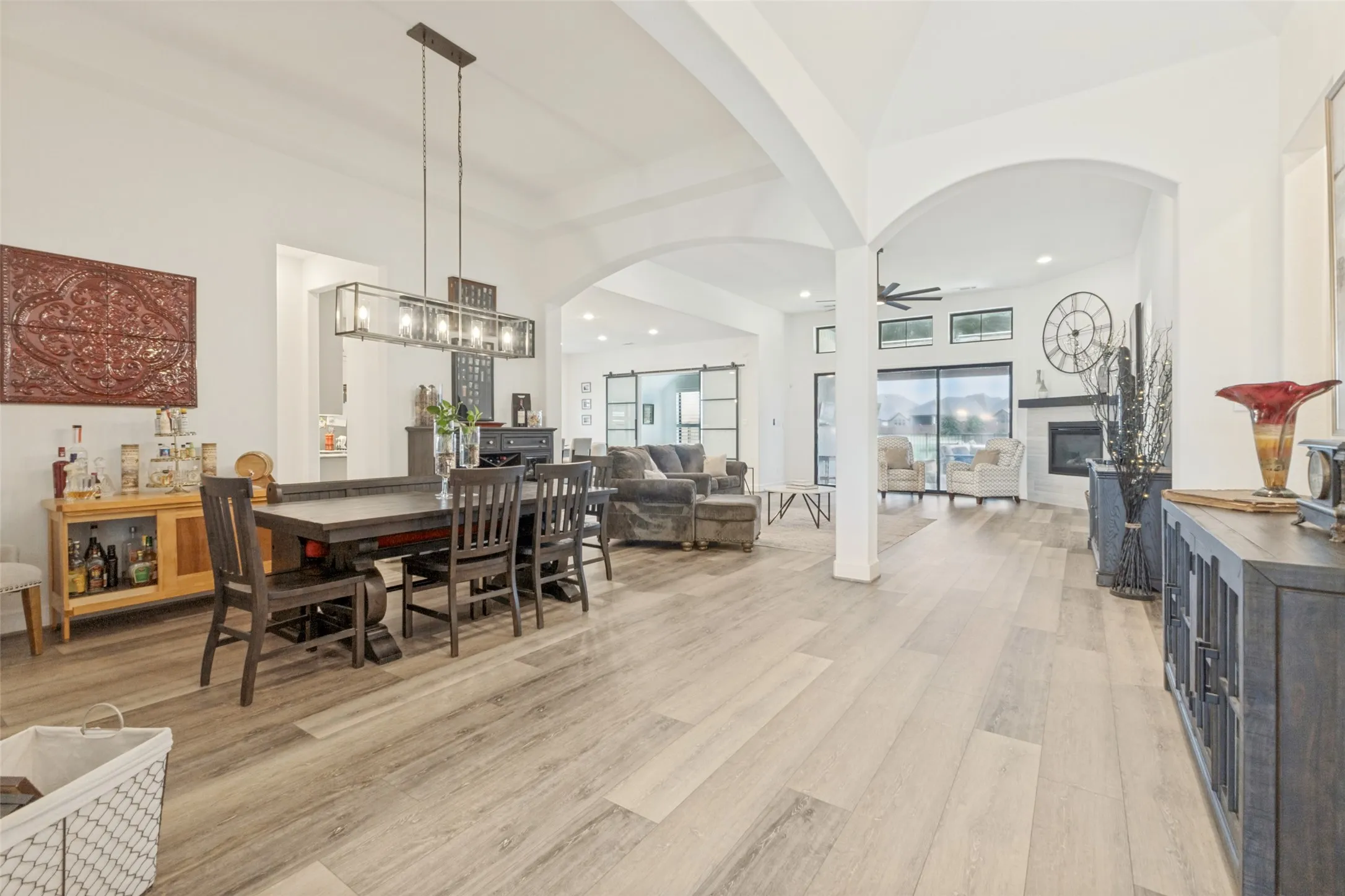 Expansive common area featuring wood-finish flooring, vaulted ceilings, and arched doorways