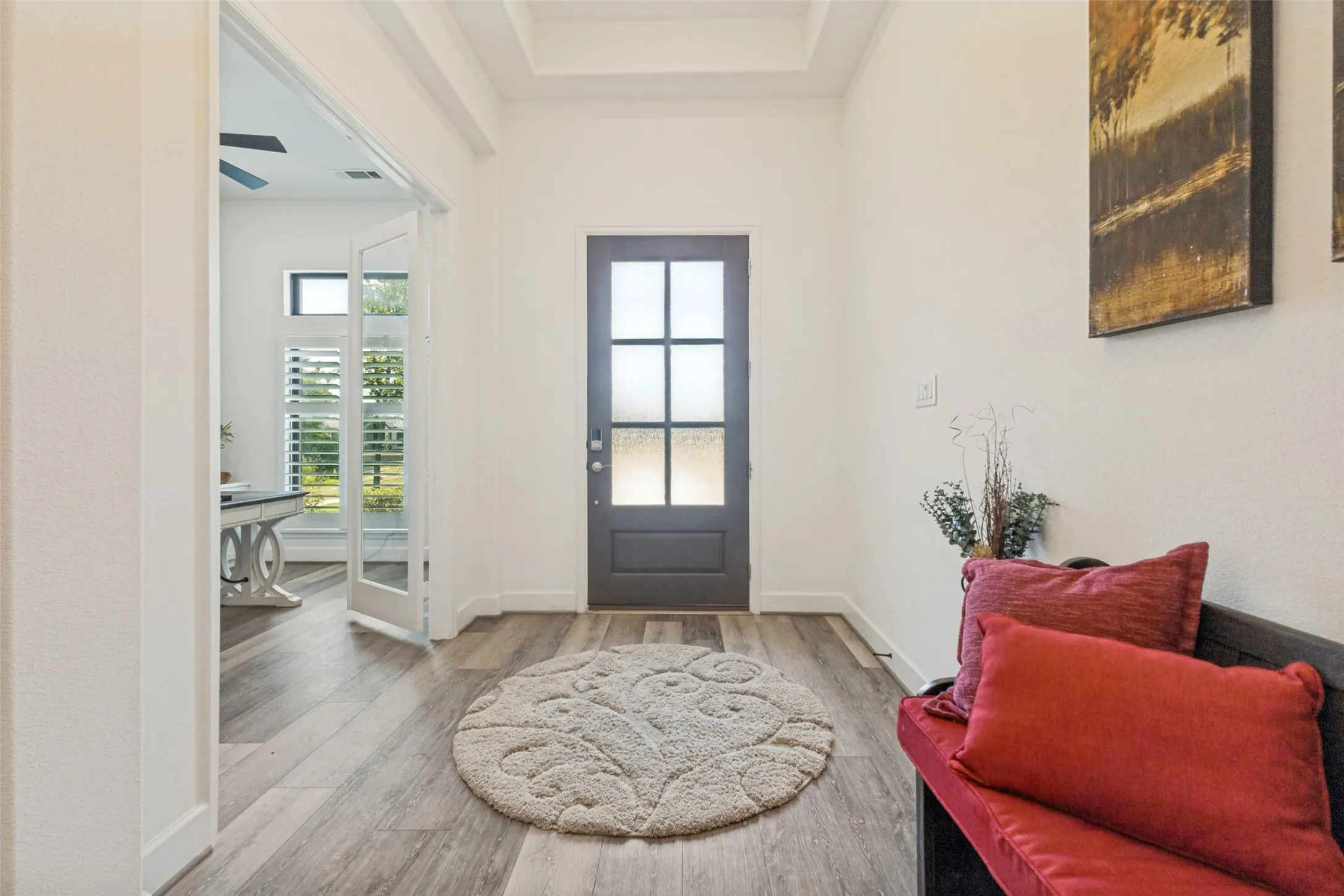 Entryway featuring a six-panel glass door, wood-finish flooring, and a coffered ceiling