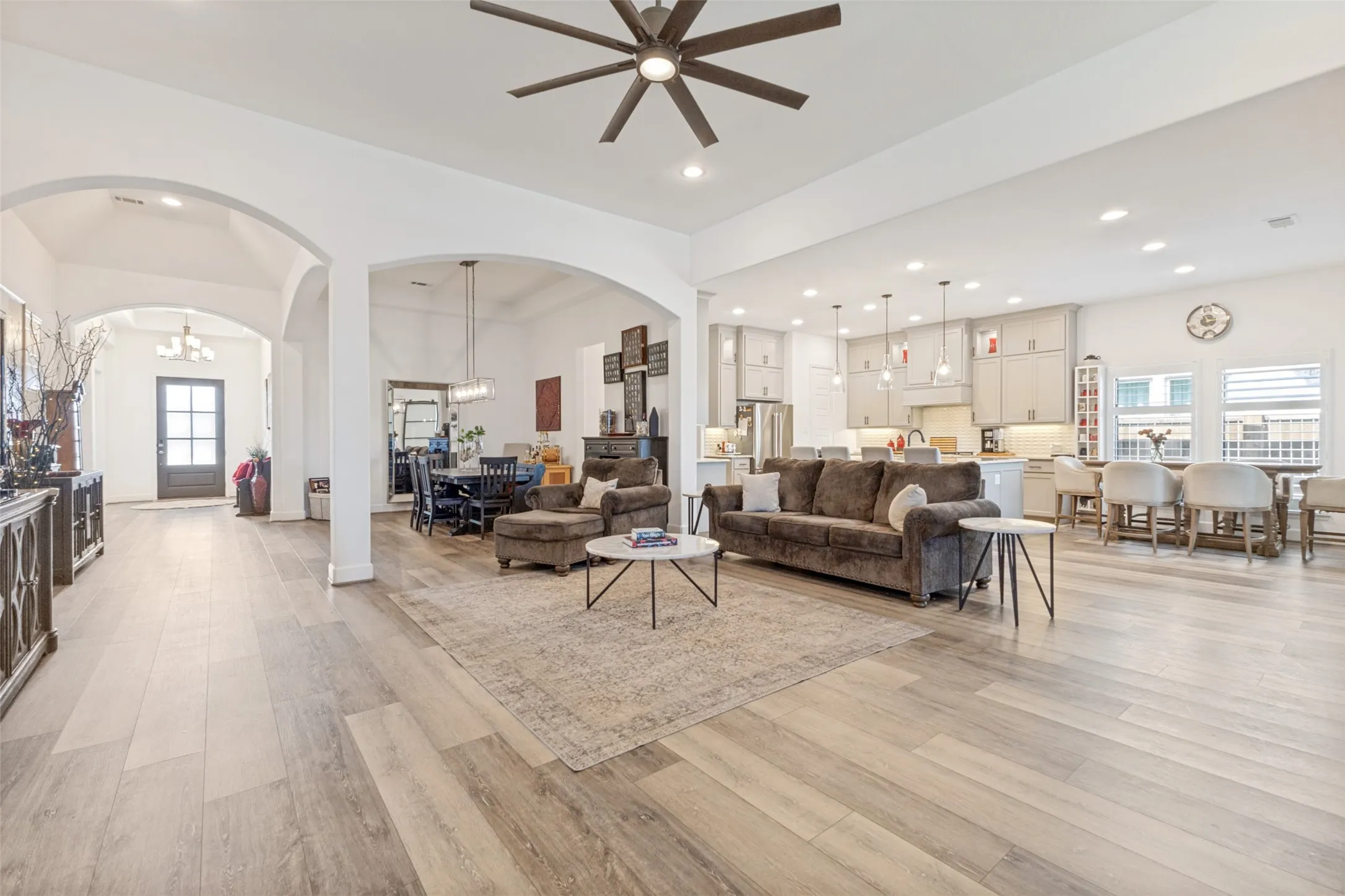 Open-concept living area featuring wood-finish flooring, recessed lighting, and a ceiling fan