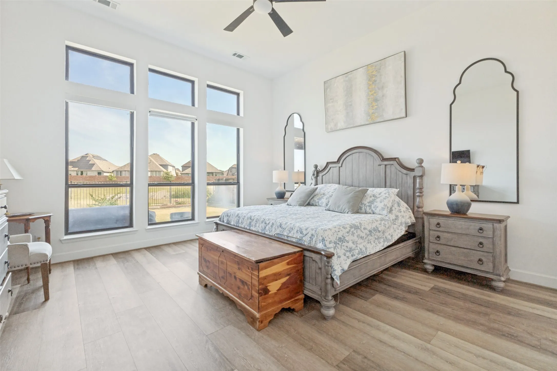 Wood-finish flooring, high ceilings, ceiling fan, and expansive windows