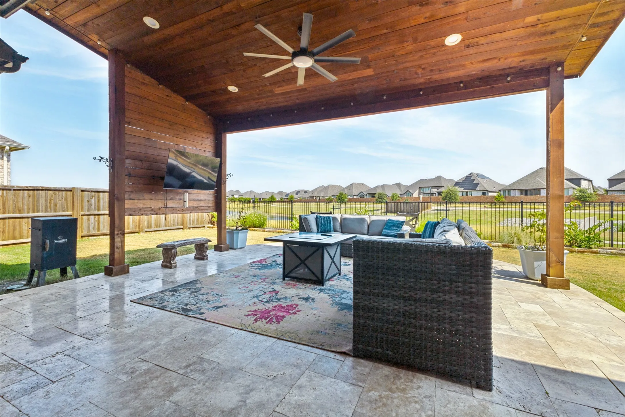 Expansive covered patio featuring a wood-panel ceiling, recessed lighting, and a ceiling fan