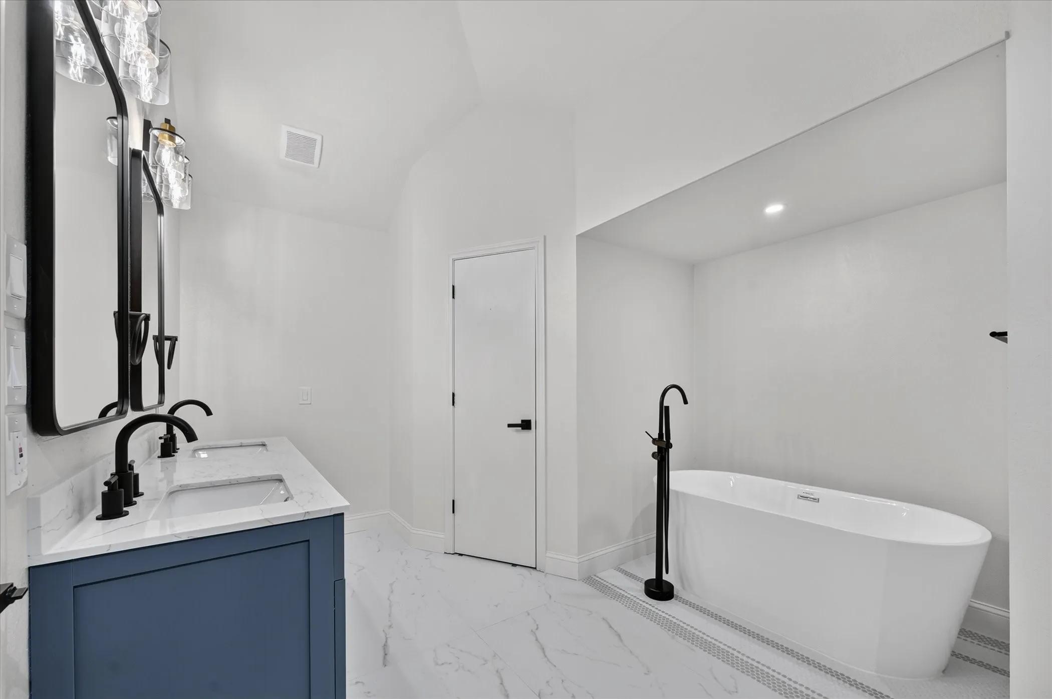 Dual vanity with a blue cabinet, rectangular sinks, and black fixtures