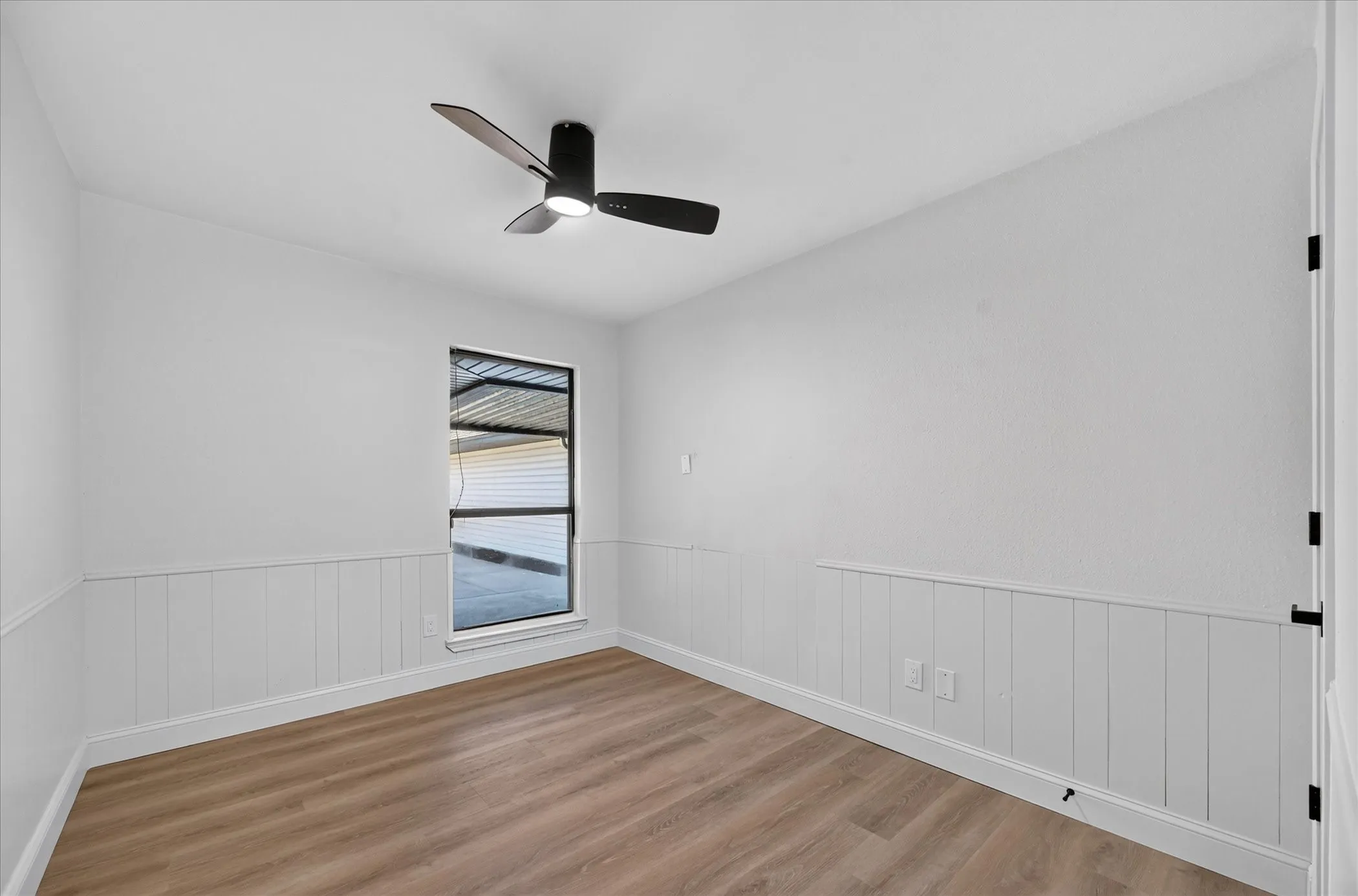 Wood-finish flooring, white trim, off-white walls, window with blinds, and a ceiling fan with light