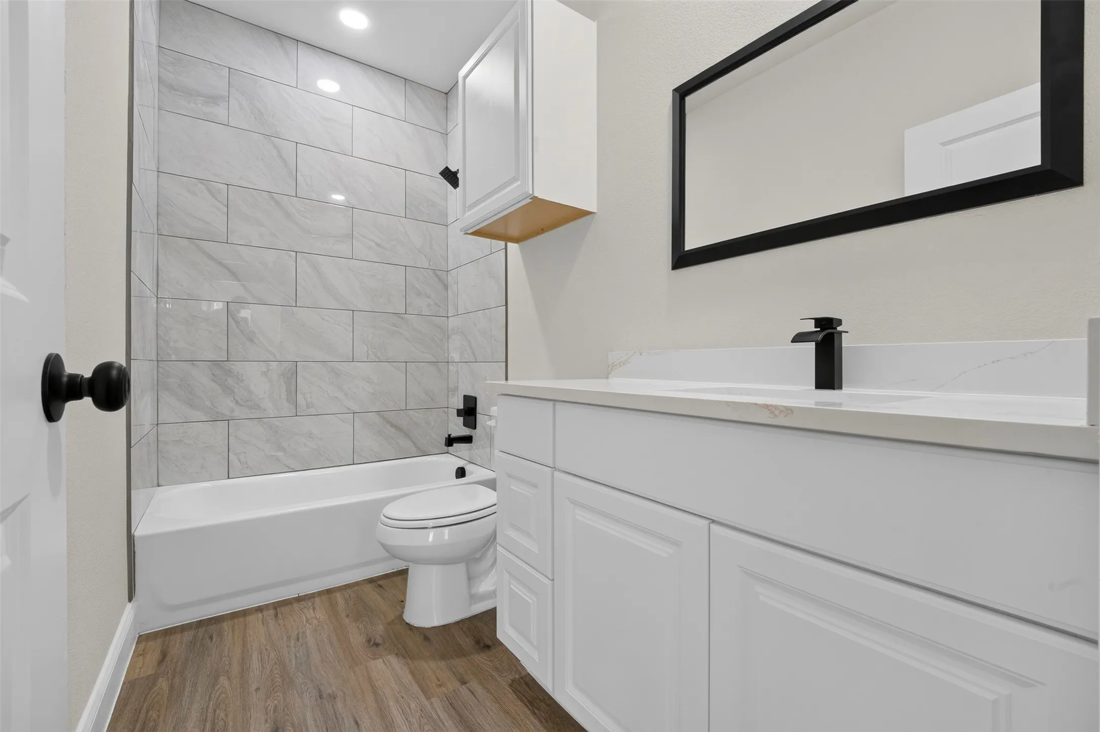 Built-in vanity with white cabinetry, white countertop, and black faucet