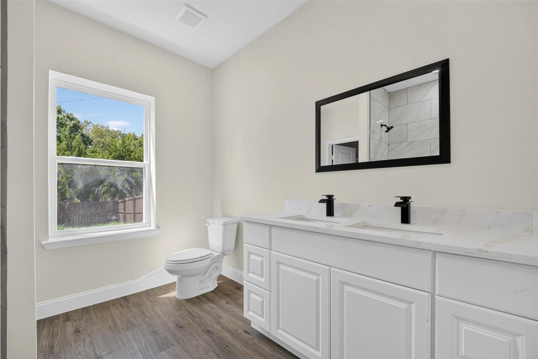 Dual white vanity with undermount sinks, quartz countertops, and matte black faucets