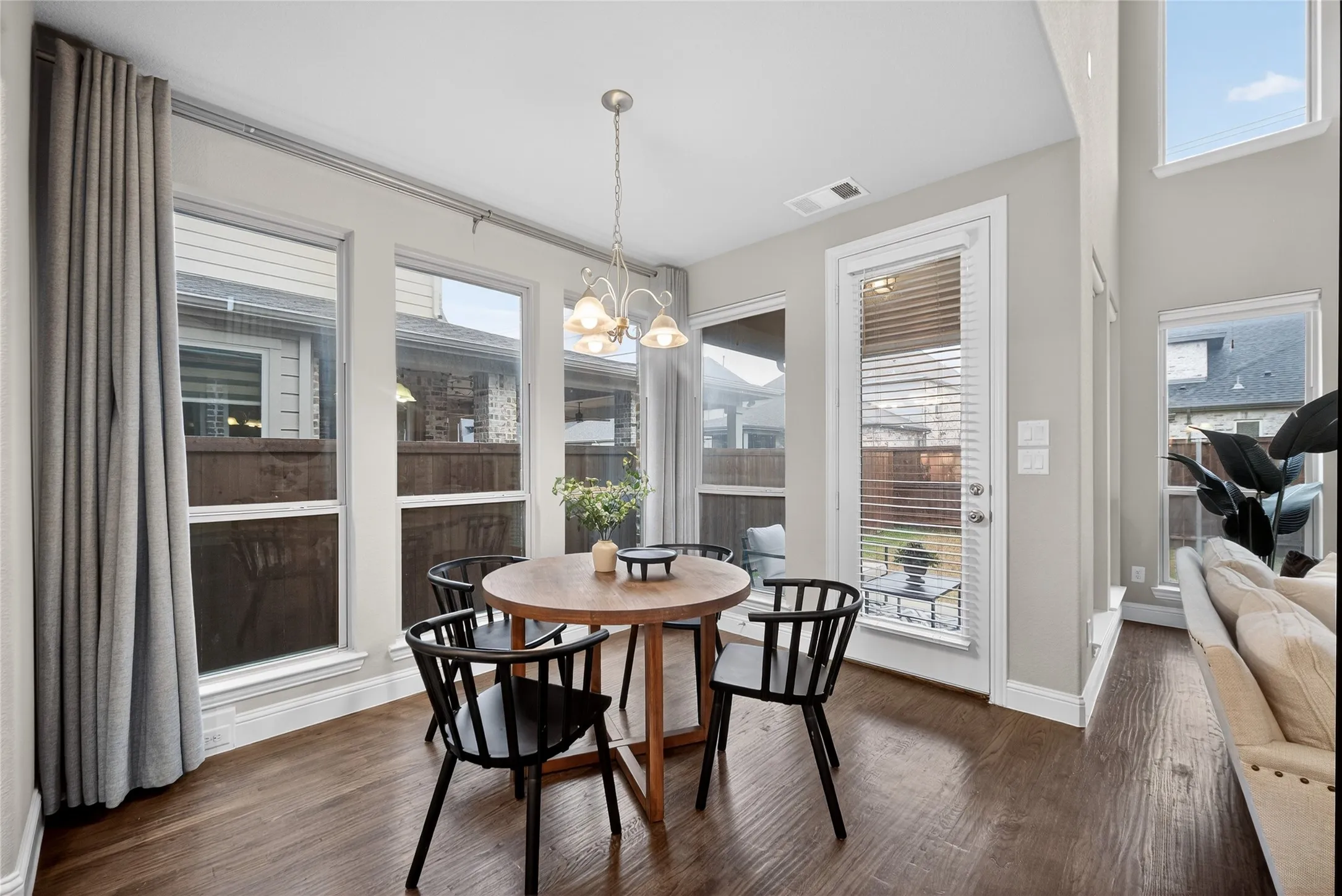 Wood-finish flooring, multiple large windows, and a glass-paneled exterior door