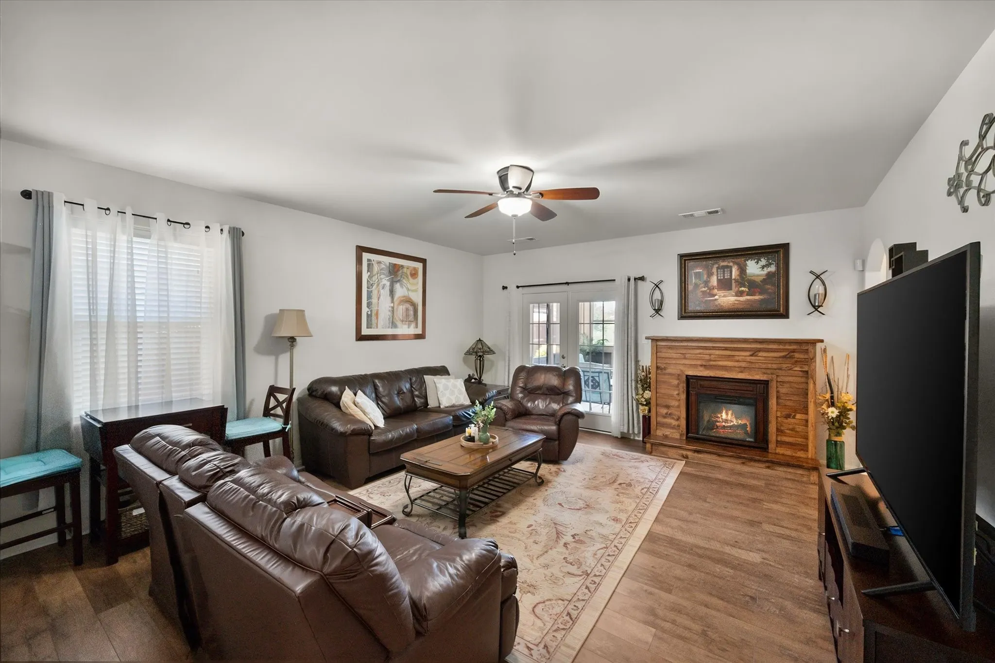 Living area featuring wood-finish flooring, a ceiling fan