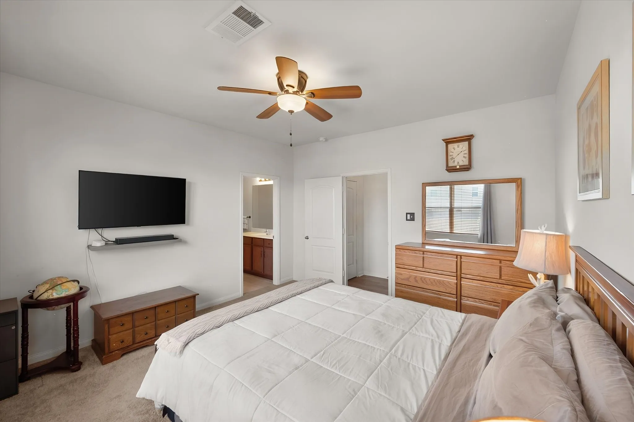 Recessed lighting, ceiling fan with integrated light, wall-mounted display, and direct access to a private bathroom