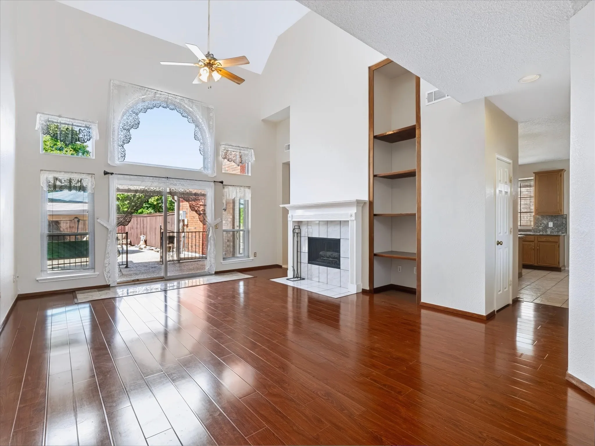 Vaulted ceilings, a ceiling fan, and hardwood flooring