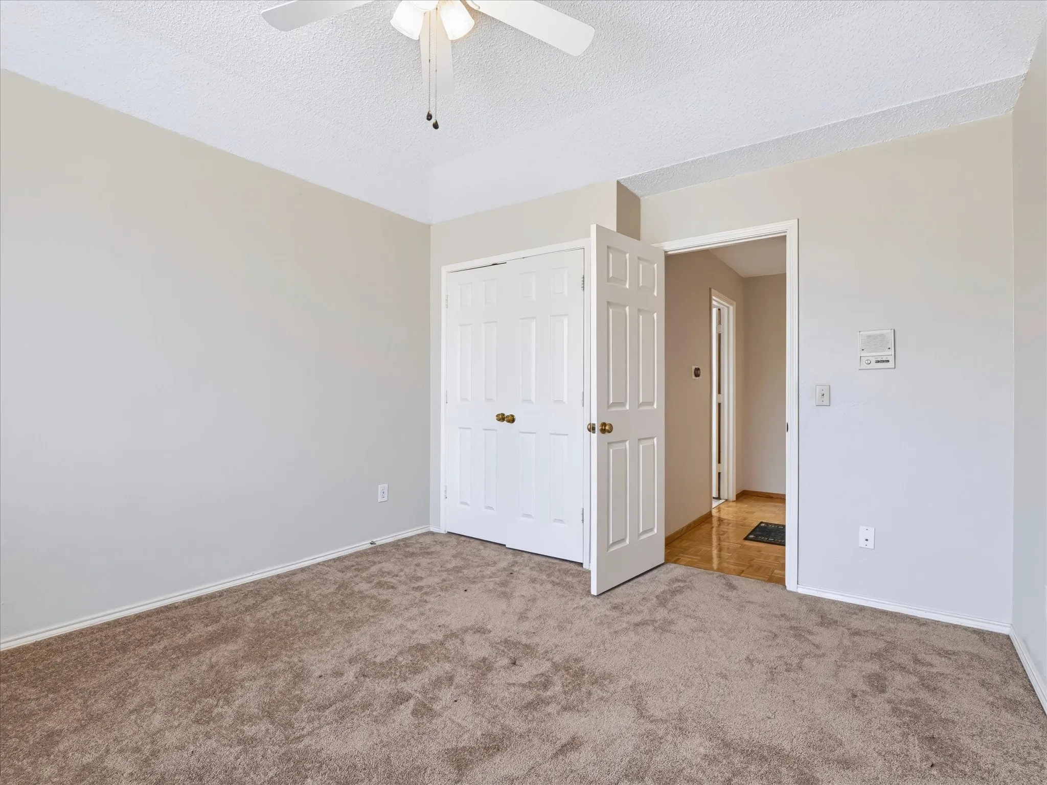Wall-to-wall carpeting, ceiling fan, and painted walls